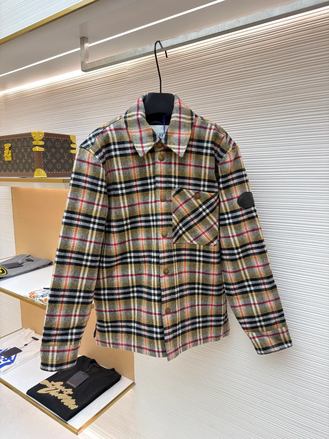 Burberry plaid wool lapel cotton coat ●Original version: Purchased and developed by 7353 ●Item number: 1681919-B40 ●Fabric: wool blended fabric ●Technology: Made on positioning cutting machine ●Color: Khaki ●Version: Fitted version ●Weight: about 800 grams ●Size: S-M-L-XL ●Description: This plaid shirt-style jacket is made of mixed-color wool blend fabric. It is combed to enhance the velvet feel and warmth, and the surface presents a natural variegated texture. The plaid pattern is based on khaki, with gray and red contrasting lines superimposed. The positioning printing process ensures that the plaid pattern is aligned when the pieces are spliced. The placket is made of vintage metal snaps, which are wear-resistant and have a thick texture; the left chest patch pocket is designed with diagonal splicing, and the bag mouth is reinforced with double-line sewing. The neckline is a classic lapel with seamed edges; the cuffs are single-button adjustable, and the inner lining is made of cotton of the same color to improve wearing comfort. The overall stitching density reaches 12 stitches/inch, and the double hemming process on the hem enhances durability. It is suitable for layering or single wear in autumn and winter. The overall wiring is straight and delicate, the fabric is comfortable and soft, and the color is consistent without color difference. It can be matched with the same style to create a fashionable look and control various occasions. Customized accessories, complete with three standards, same style for men and women!