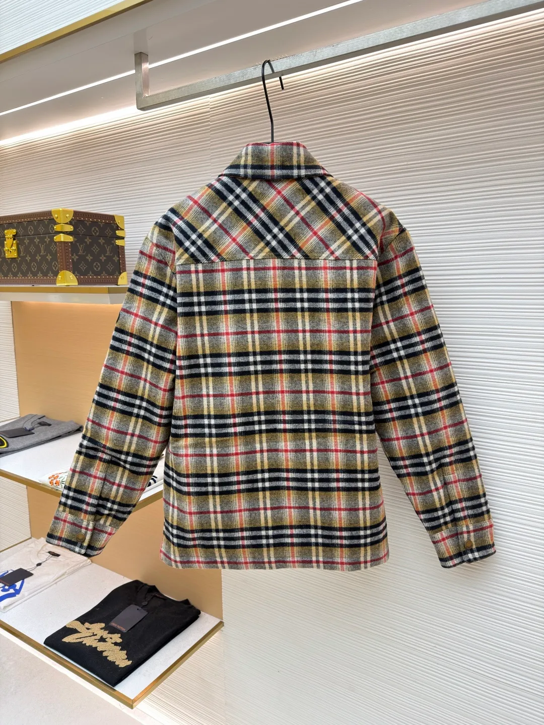 Burberry plaid wool lapel cotton coat ●Original version: Purchased and developed by 7353 ●Item number: 1681919-B40 ●Fabric: wool blended fabric ●Technology: Made on positioning cutting machine ●Color: Khaki ●Version: Fitted version ●Weight: about 800 grams ●Size: S-M-L-XL ●Description: This plaid shirt-style jacket is made of mixed-color wool blend fabric. It is combed to enhance the velvet feel and warmth, and the surface presents a natural variegated texture. The plaid pattern is based on khaki, with gray and red contrasting lines superimposed. The positioning printing process ensures that the plaid pattern is aligned when the pieces are spliced. The placket is made of vintage metal snaps, which are wear-resistant and have a thick texture; the left chest patch pocket is designed with diagonal splicing, and the bag mouth is reinforced with double-line sewing. The neckline is a classic lapel with seamed edges; the cuffs are single-button adjustable, and the inner lining is made of cotton of the same color to improve wearing comfort. The overall stitching density reaches 12 stitches/inch, and the double hemming process on the hem enhances durability. It is suitable for layering or single wear in autumn and winter. The overall wiring is straight and delicate, the fabric is comfortable and soft, and the color is consistent without color difference. It can be matched with the same style to create a fashionable look and control various occasions. Customized accessories, complete with three standards, same style for men and women!