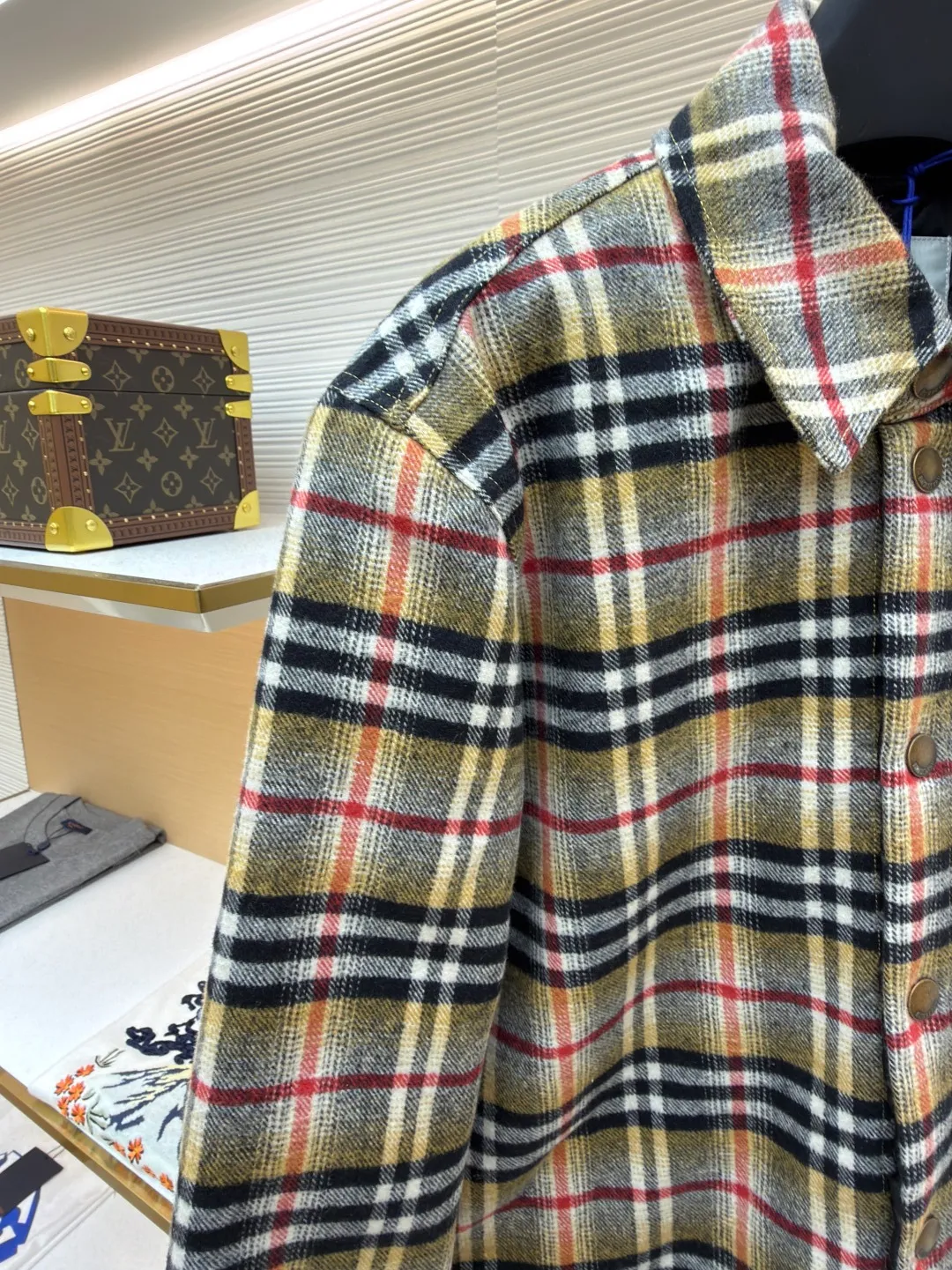 Burberry plaid wool lapel cotton coat ●Original version: Purchased and developed by 7353 ●Item number: 1681919-B40 ●Fabric: wool blended fabric ●Technology: Made on positioning cutting machine ●Color: Khaki ●Version: Fitted version ●Weight: about 800 grams ●Size: S-M-L-XL ●Description: This plaid shirt-style jacket is made of mixed-color wool blend fabric. It is combed to enhance the velvet feel and warmth, and the surface presents a natural variegated texture. The plaid pattern is based on khaki, with gray and red contrasting lines superimposed. The positioning printing process ensures that the plaid pattern is aligned when the pieces are spliced. The placket is made of vintage metal snaps, which are wear-resistant and have a thick texture; the left chest patch pocket is designed with diagonal splicing, and the bag mouth is reinforced with double-line sewing. The neckline is a classic lapel with seamed edges; the cuffs are single-button adjustable, and the inner lining is made of cotton of the same color to improve wearing comfort. The overall stitching density reaches 12 stitches/inch, and the double hemming process on the hem enhances durability. It is suitable for layering or single wear in autumn and winter. The overall wiring is straight and delicate, the fabric is comfortable and soft, and the color is consistent without color difference. It can be matched with the same style to create a fashionable look and control various occasions. Customized accessories, complete with three standards, same style for men and women!