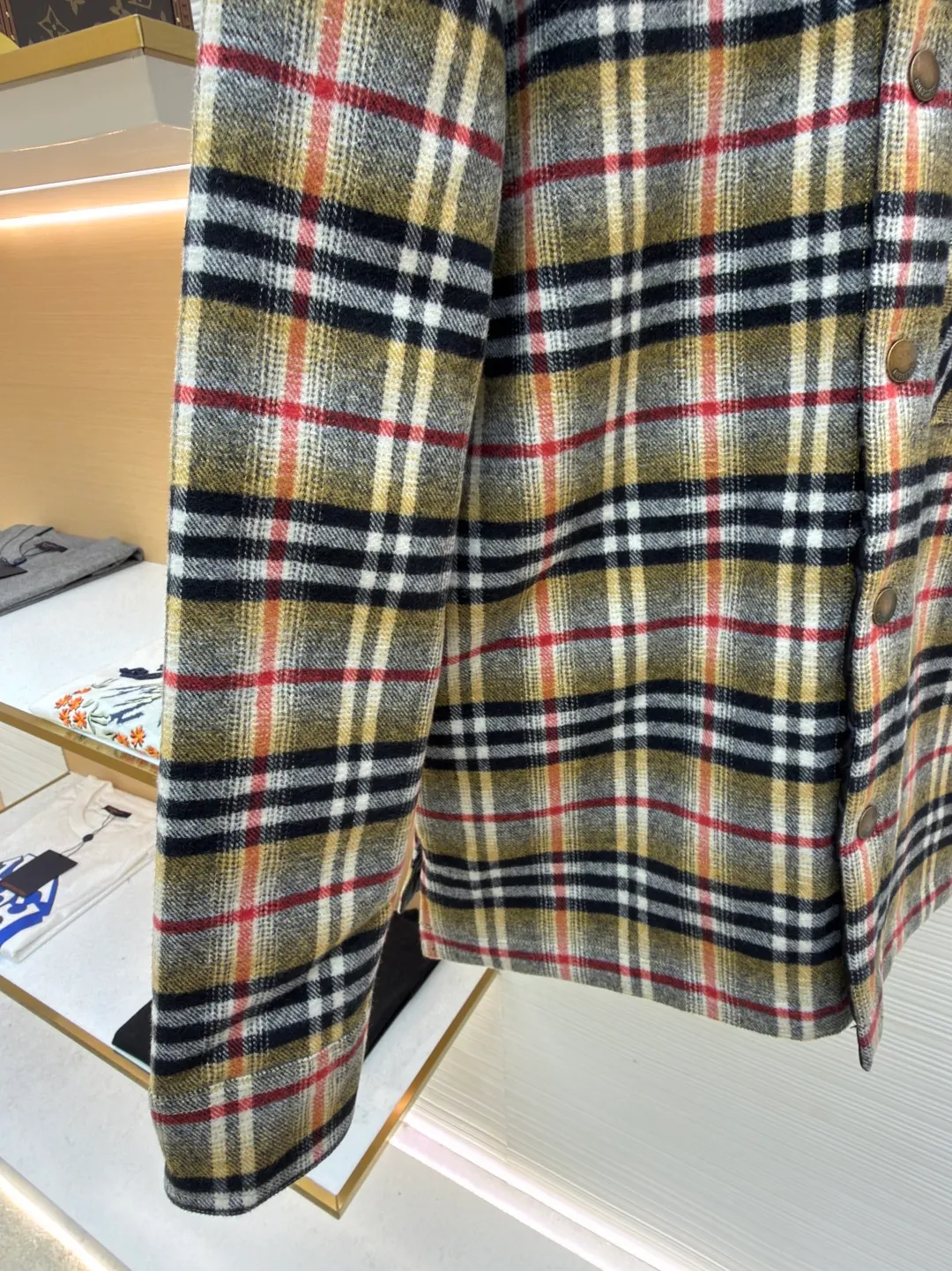Burberry plaid wool lapel cotton coat ●Original version: Purchased and developed by 7353 ●Item number: 1681919-B40 ●Fabric: wool blended fabric ●Technology: Made on positioning cutting machine ●Color: Khaki ●Version: Fitted version ●Weight: about 800 grams ●Size: S-M-L-XL ●Description: This plaid shirt-style jacket is made of mixed-color wool blend fabric. It is combed to enhance the velvet feel and warmth, and the surface presents a natural variegated texture. The plaid pattern is based on khaki, with gray and red contrasting lines superimposed. The positioning printing process ensures that the plaid pattern is aligned when the pieces are spliced. The placket is made of vintage metal snaps, which are wear-resistant and have a thick texture; the left chest patch pocket is designed with diagonal splicing, and the bag mouth is reinforced with double-line sewing. The neckline is a classic lapel with seamed edges; the cuffs are single-button adjustable, and the inner lining is made of cotton of the same color to improve wearing comfort. The overall stitching density reaches 12 stitches/inch, and the double hemming process on the hem enhances durability. It is suitable for layering or single wear in autumn and winter. The overall wiring is straight and delicate, the fabric is comfortable and soft, and the color is consistent without color difference. It can be matched with the same style to create a fashionable look and control various occasions. Customized accessories, complete with three standards, same style for men and women!