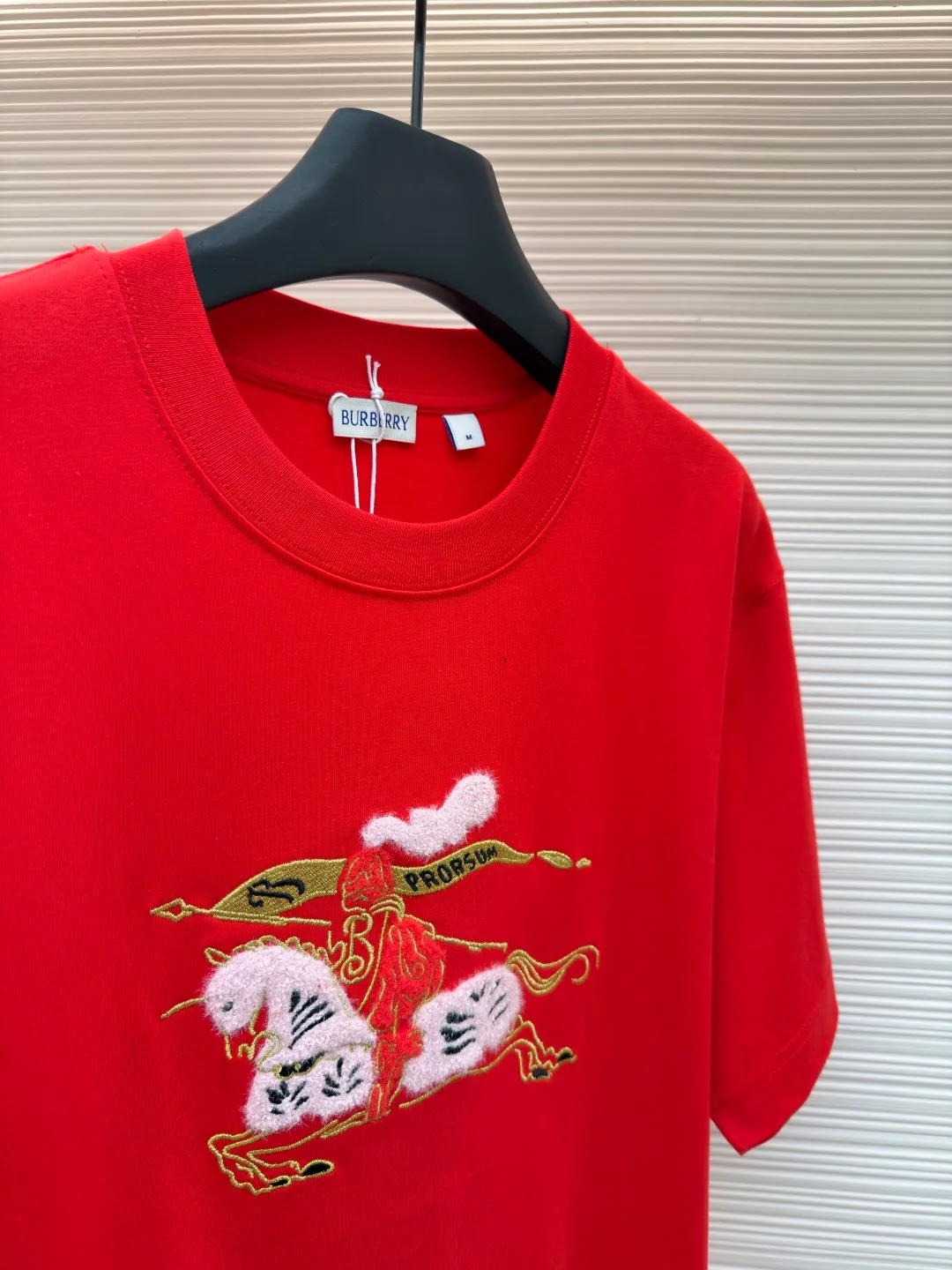 Burberry fleece pony round neck short sleeves ●Original version: Purchased and developed for 4850 ●Item number: 1682162-A05 ●Fabric: pure cotton plain weave ●Technology: embroidery production ●Color: red ●Version: fitted version ●Weight: about 265 grams ●Size: Fine cotton fabrics usually have better moisture absorption, breathability, wear resistance, and are also softer and smoother. Vintage fine cotton fabric is a relatively thick cotton fabric that has been carefully processed and treated to have excellent texture and performance. It feels soft and comfortable and fits the skin very well when worn. Craftsmanship with plush effect, new season equestrian knight logo embroidery, and metallic yarns with a rich touch are the core of the design. During the embroidery process, special yarns containing metallic threads are mixed and programmed through a computer embroidery machine to integrate the metallic yarns into specific parts of the pattern using stitching methods such as chain embroidery and tatami embroidery. On top of the traditional three-dimensional sense of embroidery, a shimmering metallic luster and a special cool touch are added, causing the classic logo pattern to produce local highlights under light, showing a reshaped modern sense and a high-end customization-like sophistication, which is highly recognizable. The overall wiring is straight and delicate, the fabric is comfortable and soft, and the color is consistent without color difference. It can be matched with the same style to create a fashionable look and control various occasions. Customized accessories, complete with three standards, same style for men and women!