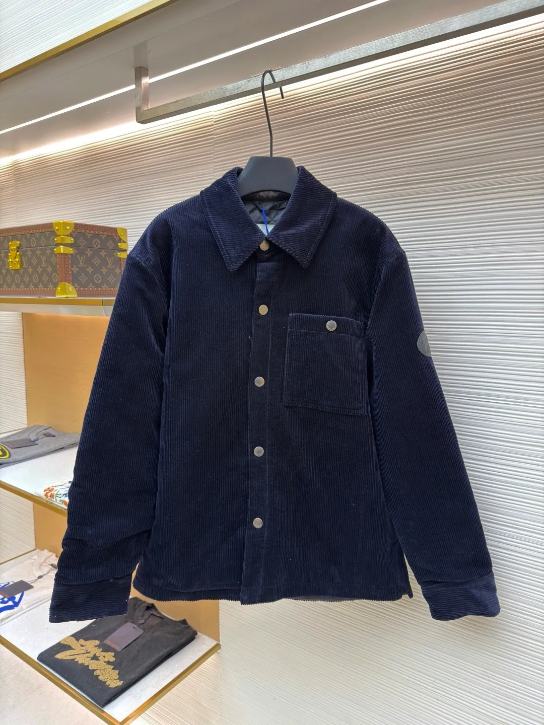Burberry solid color lapel snap-fastening cotton jacket ●Original version: purchased and developed by 8766 ●Item number: 1681956-B40 ●Fabric: 100% cotton ●Technology: Made on positioning cutting machine ●Color: navy blue ●Version: fitted version ●Weight: about 940 grams ●Size: S-M-L-XL ●Description: This LV navy corduroy jacket is made of 8 wide corduroy fabrics, which are washed and distressed. The velvet strips are full and soft to the touch, while maintaining wrinkle resistance. The body of the garment adopts a whole-piece cutting process to ensure that the vertical texture of the corduroy is consistent and uninterrupted, and the splicing is sewn with invisible embedded clips, making the appearance more tidy. The chest patch pocket is made of double-layer quilted fabric, and the edges of the bag flap are edged with the same material. It is equipped with matte metal snap buttons, and the buckle surface is sandblasted to give a low-key texture. The ribs on the cuffs and hem are made of the same fabric and are elastic to fit the body shape. The left arm decorative plate is made of embossed + vegetable tanned leather splicing, and the brand logo is concealed and three-dimensional. The inner lining is lined with thin nylon interlining to improve the smoothness of putting on and taking off. The overall stitching stitches are evenly spaced (8 stitches per centimeter), taking into account the retro texture and practical durability. The overall wiring is straight and delicate, the fabric is comfortable and soft, and the color is consistent without color difference. It can be matched with the same style to create a fashionable look and control various occasions. Customized accessories, complete with three standards, same style for men and women!
