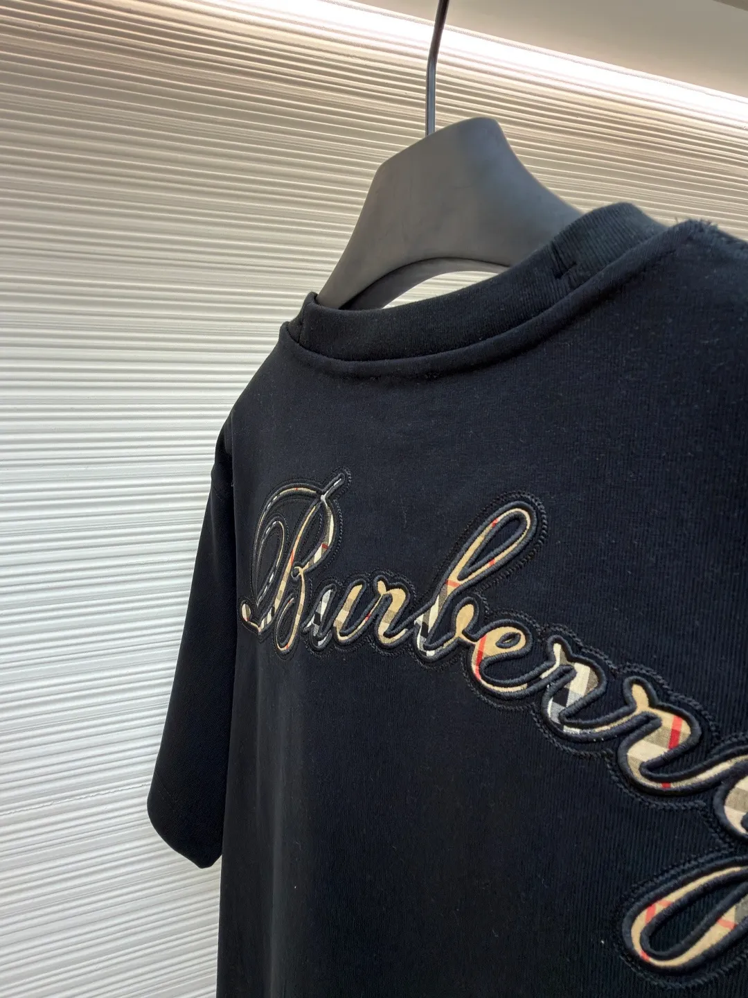 Burberry Plaid Back Letter Embroidered Round Neck Short Sleeve ●Original: Purchased and developed by 4984 ●Item No.: 1681563-A10 ●Material: pure cotton fabric ●Technology: embroidery production ●Color: black ●Version: fitted version ●Weight: about 380g ●Size: XS-S-M-L ●Description: Made of 15S fine cotton plain weave, white/230g, black/310g; matching 32S double yarn tension frame thread, 300g. Made of pure cotton plain woven fabric, this weave has a tight structure, giving the fabric a crisp texture and excellent durability, while retaining the natural breathability and skin-friendly properties of cotton. The plain woven fabric is not easy to deform, avoids being too loose and casual, and provides a neater silhouette. The chest and back are embellished with letter logo embroidery, forming a visual rhythm that echoes the front and back, both presented through chain stitch embroidery technology. These logos also use high-precision embroidery technology to ensure clear edges, strong and durable. Unique embroidery technique, its stitches are interlocking like a chain, making it more three-dimensional, softer to the touch, and has a unique texture and luster. Presenting the classic plaid pattern with this process is an innovative deconstruction of the traditional elements of the brand. It transforms the original flat pattern into a three-dimensional texture with handicraft warmth, which greatly enhances the sophistication and value of the design. The overall wiring is straight and delicate, the fabric is comfortable and soft, and the color is consistent without color difference. It can be matched with the same style to create a fashionable look and control various occasions. Customized accessories, complete with three standards, same style for men and women!