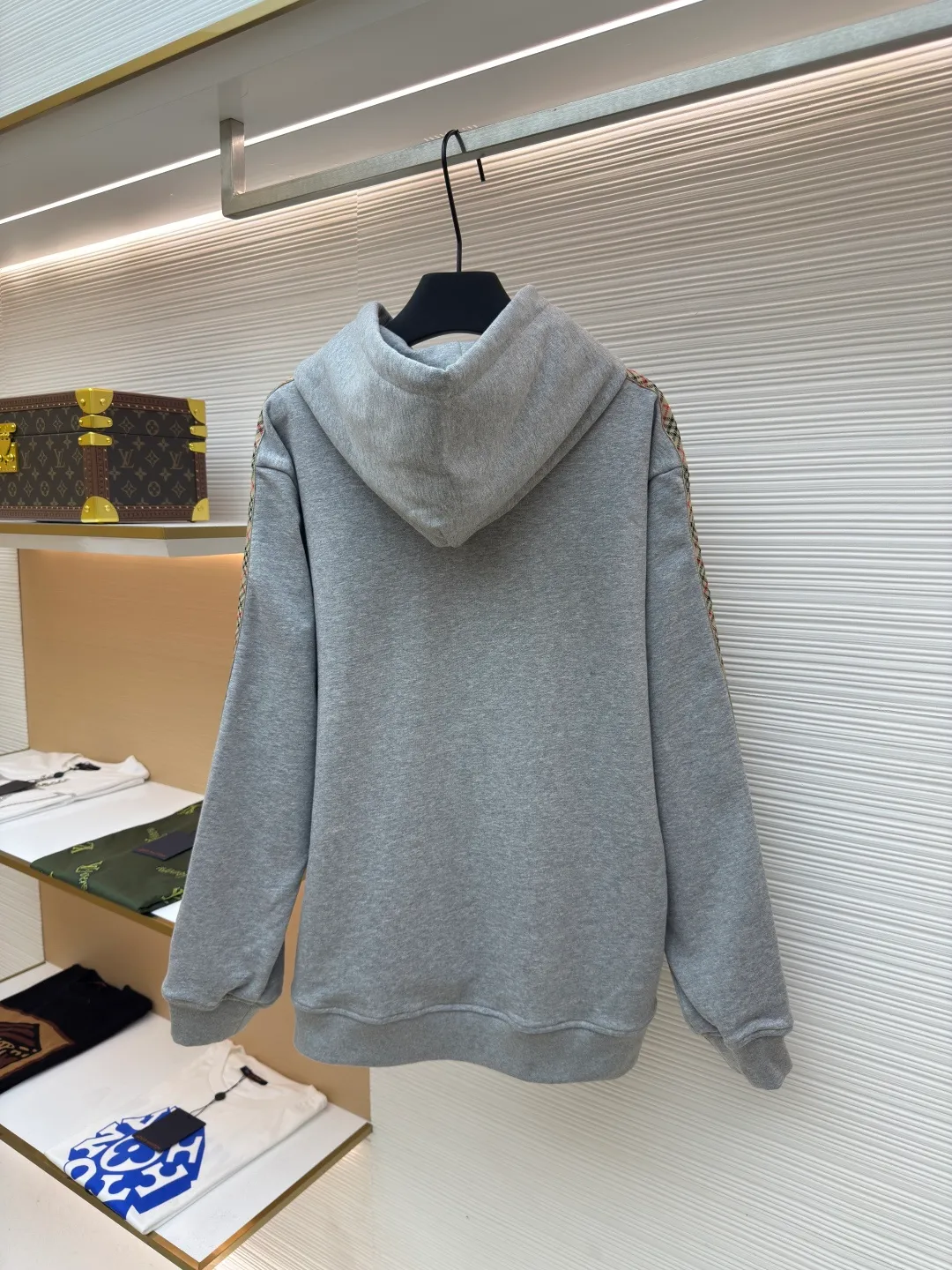 BURBERRY Ribbon trim hooded pullover sweatshirt ●Authentic product: Purchased and developed by 6239 ●Item number: 1680510-B15 ●Fabric: single-sided fish scale fabric ●Technology: selvedge production ●Version: fitted version ●Weight: about 855 grams ●Size: S-M-L-XL ●Description: A single-sided fish-scale cloth fabric woven with cotton as the base. The front is a smooth knitted surface, and the skin-contacting surface is formed into three-dimensional terry by the floating thread knitting technology of the knitting machine, which increases the fluffiness and has a delicate touch. The terry structure absorbs a large amount of water and evaporates quickly, so it is not easy to loosen and deform after repeated washing. By actively interfering with the shrinkage potential of cotton fibers, the fabric is able to transition from changeable to stable, improving dimensional stability while being less prone to deformation and wrinkles. The monochrome flat embroidery on the chest uses the high-precision calculation system of the computer embroidery machine to control the coordinated operation of the machine head, needle bar, and thread spool. The fabric frame moves accurately in the horizontal and vertical directions to form a stitch track. The upper and lower thread tensions are adjusted to ensure that the stitches are smooth and free of floating threads, forming a fine pattern with an error of ±0.1mm. The overall wiring is straight and delicate, the fabric is comfortable and soft, and the color is consistent without color difference. It can be matched with the same style to create a fashionable look and control various occasions. Customized accessories, complete with three standards, same style for men and women!