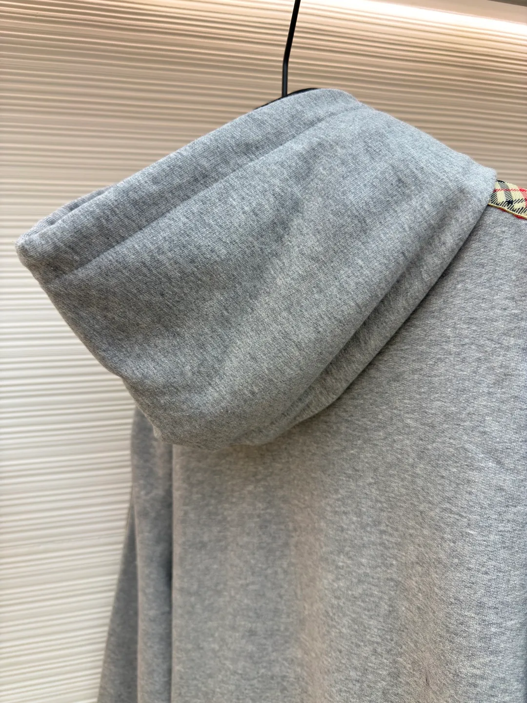 BURBERRY Ribbon trim hooded pullover sweatshirt ●Authentic product: Purchased and developed by 6239 ●Item number: 1680510-B15 ●Fabric: single-sided fish scale fabric ●Technology: selvedge production ●Version: fitted version ●Weight: about 855 grams ●Size: S-M-L-XL ●Description: A single-sided fish-scale cloth fabric woven with cotton as the base. The front is a smooth knitted surface, and the skin-contacting surface is formed into three-dimensional terry by the floating thread knitting technology of the knitting machine, which increases the fluffiness and has a delicate touch. The terry structure absorbs a large amount of water and evaporates quickly, so it is not easy to loosen and deform after repeated washing. By actively interfering with the shrinkage potential of cotton fibers, the fabric is able to transition from changeable to stable, improving dimensional stability while being less prone to deformation and wrinkles. The monochrome flat embroidery on the chest uses the high-precision calculation system of the computer embroidery machine to control the coordinated operation of the machine head, needle bar, and thread spool. The fabric frame moves accurately in the horizontal and vertical directions to form a stitch track. The upper and lower thread tensions are adjusted to ensure that the stitches are smooth and free of floating threads, forming a fine pattern with an error of ±0.1mm. The overall wiring is straight and delicate, the fabric is comfortable and soft, and the color is consistent without color difference. It can be matched with the same style to create a fashionable look and control various occasions. Customized accessories, complete with three standards, same style for men and women!
