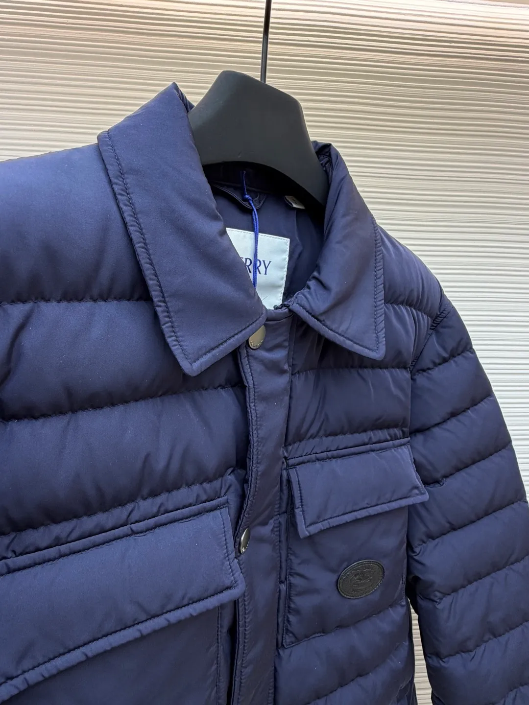 Burberry light leather label down jacket ●Original version: Purchased and developed by 6125 ●Item number: 1681879-C95 ●Fabric: white duck down fabric ●Technology: mechanical down filling ●Color: navy blue ●Version: fitted version ●Weight: about 780 grams ●Size: S-M-L-XL ●Description: High-density nylon taffeta: Made of 100D nylon fabric, density ≥230T, durable Slightly calendered (showing low-key luster), and fluorine-free waterproof coating (DWR) to ensure water repellency while maintaining breathability (refer to the slightly wrinkled texture and stiffness of the fabric in the picture) Anti-velvet gallbladder: Use high-density polyester gallbladder cloth (such as gallbladder silk spinning) above 300T to ensure that the down does not rip through velvet, and is light and thin without affecting the fluffiness. Filling 900-fill white duck down (85%-90% down content) ensures a full three-dimensional effect but not too bloated. It uses YKK brand No. 5 nylon zipper (matte dark gray/black, close to the fabric). The zipper teeth are fine-toothed and flat-toothed. The puller is simple and square. The brand logo is etched on the surface. The outside of the zipper needs to be seamed. 1.5cm wide windproof placket made of the same color fabric (double-layered, with thin cotton strips sandwiched inside to increase stiffness). The cuffs are fake two-piece design (the outer layer is folded cuffs, and the inner layer is ribbed). The outer cuffs are equipped with 2 metal buttons (diameter 12mm, the same series as the pocket snaps), with a spacing of 3cm. The buttonholes are hand-made keyholes (double-line seaming, precise aperture). They are made of first-layer calfskin (thickness 0.8-mm). The leather surface is matte aniline dyed and the edges are warped. Oil edge treatment (thickness 0.3mm, round and smooth, color consistent with leather label). The brand pattern (knight logo + text) on the surface of the leather label adopts embossing + hot stamping/silvering technology. The overall wiring is straight and delicate, the fabric is comfortable and soft, and the color is consistent without color difference. It can be matched with the same style to create a fashionable look and control various occasions. Customized accessories, complete with three labels, same style for men and women!