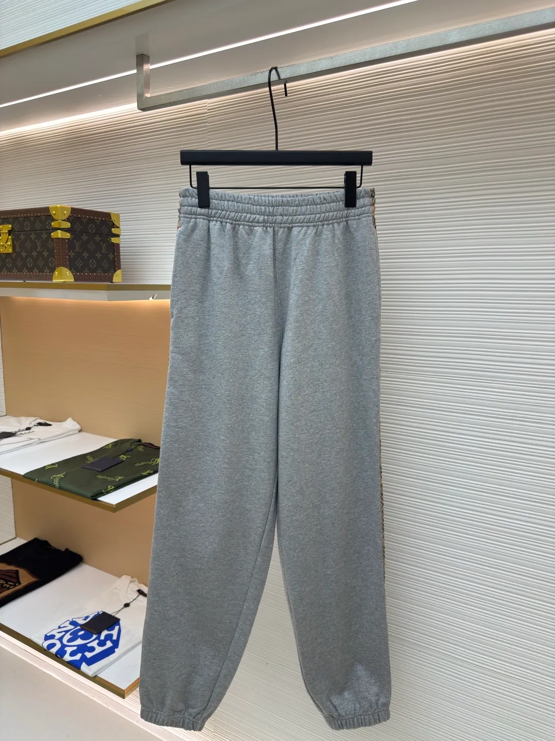 BURBERRY plaid webbing embroidered sweatpants ●Authentic product: purchased and developed by 5202 ●Item number: 1680515-A95 ●Fabric: single-sided fish scale fabric ●Technology: selvage production ●Version: fitted version ●Weight: about 705 grams ●Size: S-M-L-XL ●Description: A single-sided fish-scale cloth fabric woven with cotton as the base. The front is a smooth knitted surface, and the skin-contacting surface is formed into three-dimensional terry by the floating thread knitting technology of the knitting machine, which increases the fluffiness and has a delicate touch. The terry structure absorbs a large amount of water and evaporates quickly, so it is not easy to loosen and deform after repeated washing. By actively interfering with the shrinkage potential of cotton fibers, the fabric is able to transition from changeable to stable, improving dimensional stability while being less prone to deformation and wrinkles. The monochrome flat embroidery on the chest uses the high-precision calculation system of the computer embroidery machine to control the coordinated operation of the machine head, needle bar, and thread spool. The fabric frame moves accurately in the horizontal and vertical directions to form a stitch track. The upper and lower thread tensions are adjusted to ensure that the stitches are smooth and free of floating threads, forming a fine pattern with an error of ±0.1mm. The overall wiring is straight and delicate, the fabric is comfortable and soft, and the color is consistent without color difference. It can be matched with the same style to create a fashionable look and control various occasions. Customized accessories, complete with three standards, same style for men and women!