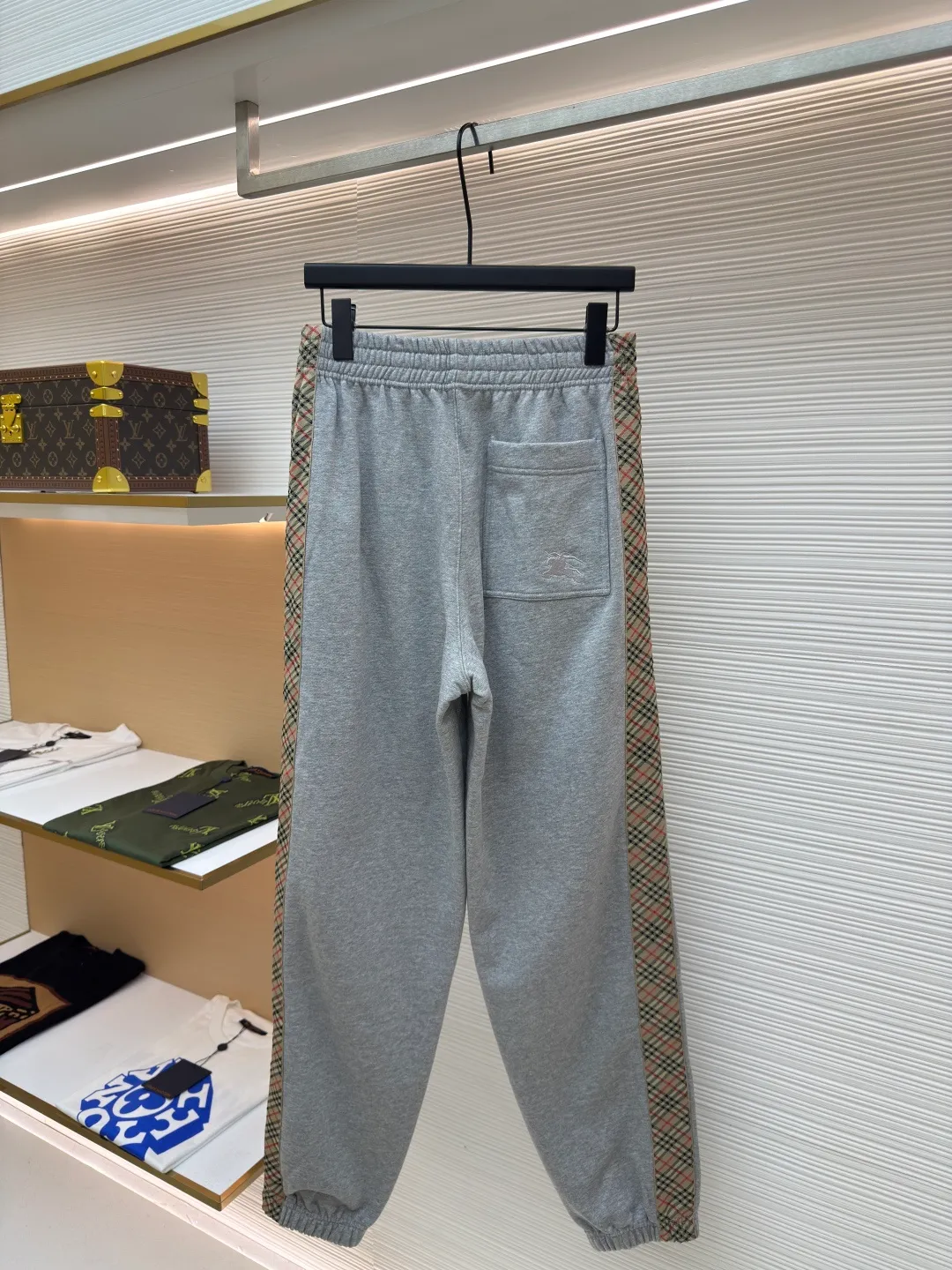 BURBERRY plaid webbing embroidered sweatpants ●Authentic product: purchased and developed by 5202 ●Item number: 1680515-A95 ●Fabric: single-sided fish scale fabric ●Technology: selvage production ●Version: fitted version ●Weight: about 705 grams ●Size: S-M-L-XL ●Description: A single-sided fish-scale cloth fabric woven with cotton as the base. The front is a smooth knitted surface, and the skin-contacting surface is formed into three-dimensional terry by the floating thread knitting technology of the knitting machine, which increases the fluffiness and has a delicate touch. The terry structure absorbs a large amount of water and evaporates quickly, so it is not easy to loosen and deform after repeated washing. By actively interfering with the shrinkage potential of cotton fibers, the fabric is able to transition from changeable to stable, improving dimensional stability while being less prone to deformation and wrinkles. The monochrome flat embroidery on the chest uses the high-precision calculation system of the computer embroidery machine to control the coordinated operation of the machine head, needle bar, and thread spool. The fabric frame moves accurately in the horizontal and vertical directions to form a stitch track. The upper and lower thread tensions are adjusted to ensure that the stitches are smooth and free of floating threads, forming a fine pattern with an error of ±0.1mm. The overall wiring is straight and delicate, the fabric is comfortable and soft, and the color is consistent without color difference. It can be matched with the same style to create a fashionable look and control various occasions. Customized accessories, complete with three standards, same style for men and women!