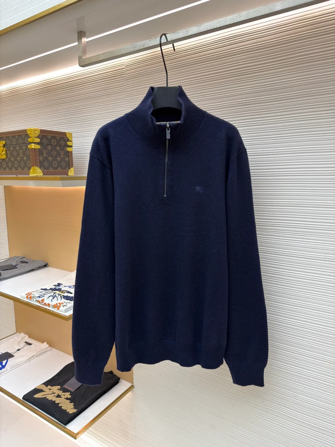 Burberry embroidered half-zip turtleneck sweater ●Original version: Purchased and developed by 4472 ●Item number: 1681783-B25 ●Material: wool blended fabric ●Technology: knitted production ●Color: navy ●Version: Fitted version ●Weight: about 545 grams ●Size: S-M-L-XL ●Description: Cashmere is used as the main body to dominate the feel, warmth and lightness of the fabric, while providing an unparalleled wearing experience. A small amount of polyamide and Lycra are added to enhance the overall durability and pilling resistance. An invisible support network is woven into the soft cashmere, and it also has a certain amount of elasticity to better fit the curves of the human body and allow it to be retracted and retracted freely. Due to the characteristics of the sweater fabric, it is stretched just right when stretching the frame, and then a hot-melt liner is used under the wool fabric piece to provide it with a certain temporary stable support to prevent it from shrinking after removal, causing pattern distortion, wrinkles and stitch dents. The high-precision calculation program system of the computer embroidery machine controls the movement of the embroidery frame in the X/Y direction, while the needle shuttles up and down, embroidering according to the set path, automatically completing thread trimming, thread jumping and other actions to form a stitch track, automatically adjusting the upper and lower thread tension to ensure that the stitches are smooth and free of floating threads, forming a war horse pattern with an error of ±0.1mm. Add detergent and preliminarily rinse the bulk goods at a water temperature of about 35 degrees to remove impurities during the production process, and then use protease to gently digest the hairiness on the surface to reduce the tendency of pilling from the root, improve the hand feel, retain softness, and eliminate irritation. After the final dehydration and drying process, the overall wiring is straight and delicate, the fabric is comfortable and soft, and the color is consistent without color difference. It can be matched with the same style to create a fashionable look and control various occasions. Customized accessories, complete with three standards, same style for men and women!