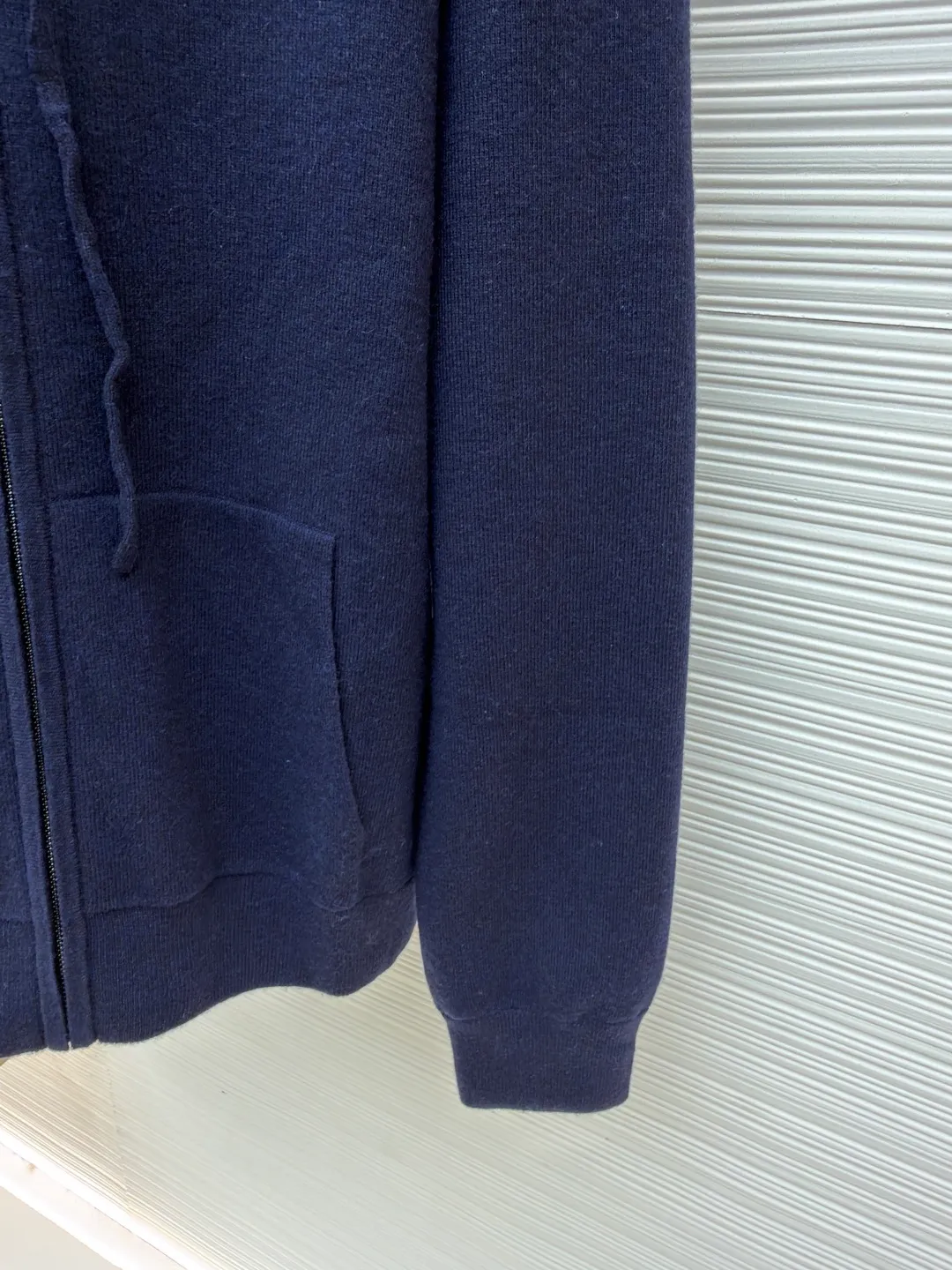 Burberry embroidered zipper cardigan ●Original version: Purchased and developed by 4766 ●Item number: 1681788-B70 ●Fabric: wool blended fabric ●Technology: knitted ●Color: navy ●Version: Fitted version ●Weight: about 875 grams ●Size: S-M-L-XL ●Description: Cashmere is the main material that dominates the feel, warmth and lightness of the fabric, while providing an unparalleled wearing experience. A small amount of polyamide and elastic fiber are added to enhance the overall durability and anti-pilling properties. An invisible support network is woven into the soft cashmere, and at the same time it has a certain amount of elasticity, which better fits the curves of the human body and can be retracted and retracted freely. Due to the characteristics of the sweater fabric, it is stretched just right when stretching the frame, and then a hot-melt liner is used under the wool fabric piece to provide it with a certain temporary stable support to prevent it from shrinking after removal, causing pattern distortion, wrinkles and stitch dents. The high-precision calculation program system of the computer embroidery machine controls the movement of the embroidery frame in the X/Y direction, while the needle shuttles up and down, embroidering according to the set path, automatically completing thread trimming, thread jumping and other actions to form a stitch track, automatically adjusting the upper and lower thread tension to ensure that the stitches are smooth and free of floating threads, forming a war horse pattern with an error of ±0.1mm. Add detergent and preliminarily rinse the bulk goods at a water temperature of about 35 degrees to remove impurities during the production process, and then use protease to gently digest the hairiness on the surface to reduce the tendency of pilling from the root, improve the hand feel, retain softness, and eliminate irritation. Finally, after dehydration and drying, the size and shape are stabilized. The overall wiring is straight and delicate, the fabric is comfortable and soft, and the color is consistent without color difference. It can be matched with the same style to create a fashionable look and control various occasions. Customized accessories, complete with three standards, same style for men and women!