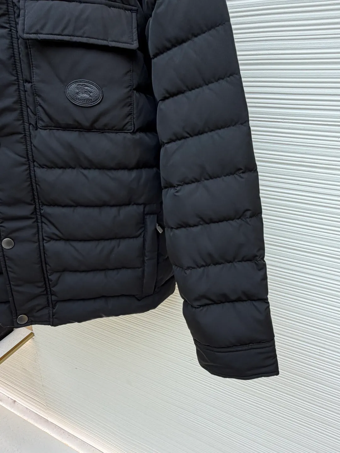 Burberry light leather label down jacket ●Original version: purchased and developed by 6125 ●Item number: 1681878-C95 ●Fabric: white duck down fabric ●Technology: mechanical down filling ●Color: black ●Version: fitted version ●Weight: about 790 grams ●Size: S-M-L-XL ●Description: High-density nylon taffeta: Made of 100D nylon fabric, density ≥230T, durable Slightly calendered (showing low-key luster), and fluorine-free waterproof coating (DWR) to ensure water repellency while maintaining breathability (refer to the slightly wrinkled texture and stiffness of the fabric in the picture) Anti-velvet gallbladder: Use high-density polyester gallbladder cloth (such as gallbladder silk spinning) above 300T to ensure that the down does not rip through velvet, and is light and thin without affecting the fluffiness. Filling 900-fill white duck down (85%-90% down content) ensures a full three-dimensional effect but not too bloated. It uses YKK brand No. 5 nylon zipper (matte dark gray/black, close to the fabric). The zipper teeth are fine-toothed and flat-toothed. The puller is simple and square. The brand logo is etched on the surface. The outside of the zipper needs to be seamed. 1.5cm wide windproof placket made of the same color fabric (double-layered, with thin cotton strips sandwiched inside to increase stiffness). The cuffs are fake two-piece design (the outer layer is folded cuffs, and the inner layer is ribbed). The outer cuffs are equipped with 2 metal buttons (diameter 12mm, the same series as the pocket snaps), with a spacing of 3cm. The buttonholes are hand-made keyholes (double-line seaming, precise aperture). They are made of first-layer calfskin (thickness 0.8-mm). The leather surface is matte aniline dyed and the edges are warped. Oil edge treatment (thickness 0.3mm, round and smooth, color consistent with leather label). The brand pattern (knight logo + text) on the surface of the leather label adopts embossing + hot stamping/silvering technology. The overall wiring is straight and delicate, the fabric is comfortable and soft, and the color is consistent without color difference. It can be matched with the same style to create a fashionable look and control various occasions. Customized accessories, complete with three labels, same style for men and women!