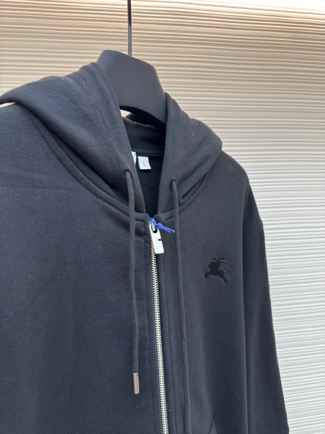 BURBERRY webbing trim embroidered hooded sweatshirt ●Authentic product: purchased and developed by 3610 ●Item number: 1680519-B50 ●Fabric: single-sided fish scale fabric ●Technology: selvedge production ●Version: fitted version ●Weight: about 950 grams ●Size: S-M-L-XL ●Description: Made of cotton as the main body, fed with 6% polyester fiber and 2% elastic fiber blend. Cotton fiber is naturally skin-friendly, soft, and highly absorbent. Its structural properties preserve the breathability of the fabric and reduce stuffiness. The addition of a small amount of elastic fiber and polyester fiber significantly improves the stretch and resilience of the fabric, while also enhancing wrinkle resistance and shape retention, and reducing shrinkage. Plaid lines form a looming relief effect through the changes in yarn color and weave, which are smooth to the touch but rich in visual layers. The jacquard process weaves the pattern into the bone, making it resistant to fading and wear and tear after repeated washing. Precise cutting and positioning cutting machine: Use positioning cutting machine equipment to accurately cut fabrics, and improve the overall quality through optical positioning and mechanical positioning. Ensure that every product meets the high standards of alignment and alignment. The overall wiring is straight and delicate, the fabric is comfortable and soft, and the color is consistent without color difference. It can be matched with the same style to create a fashionable look and control various occasions. Customized accessories, complete with three standards, same style for men and women!