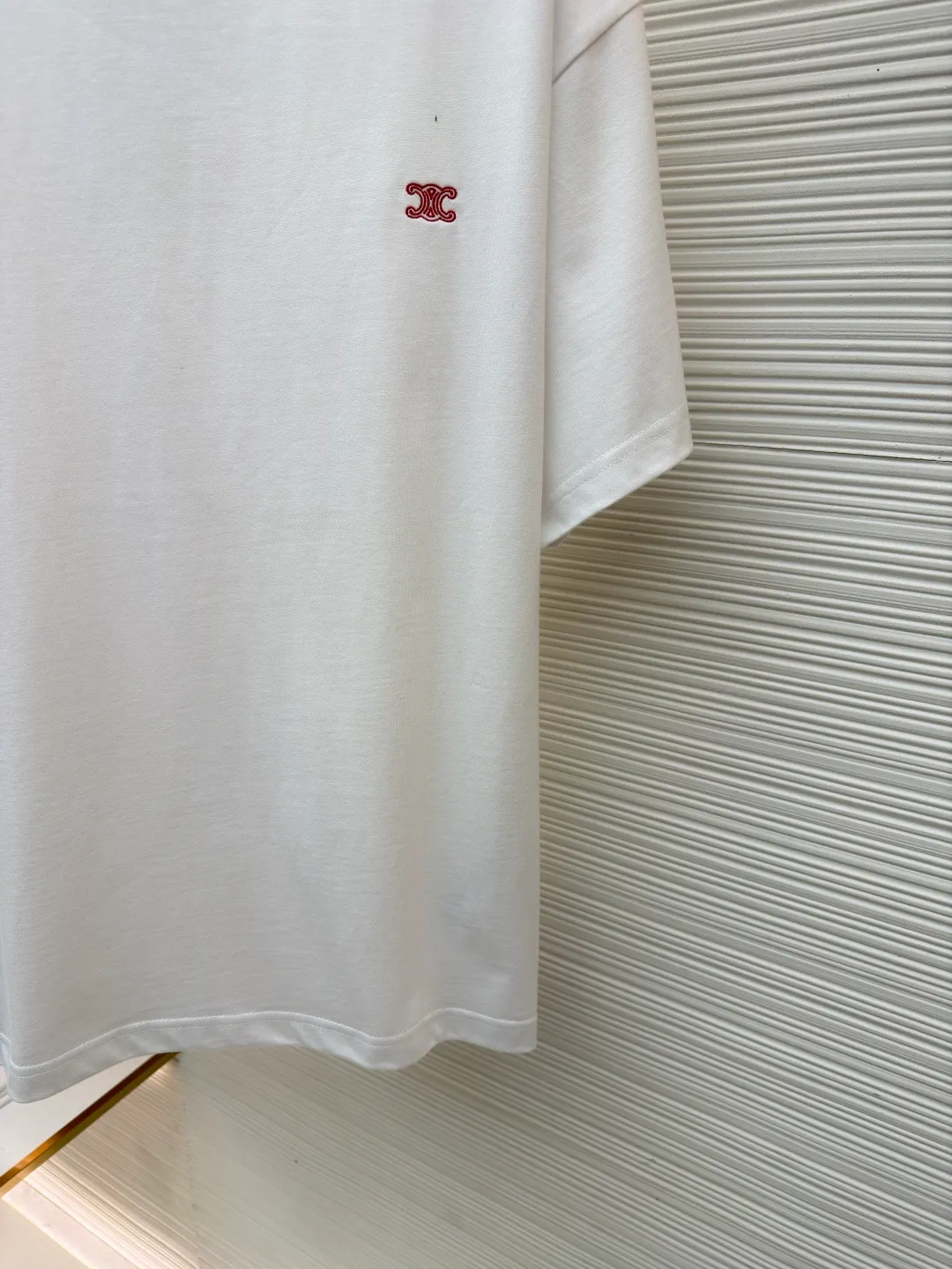 Celine Arc de Triomphe logo short sleeves ●Item number: 1682387-A00 ●Material: cotton fabric ●Technology: embroidery production ●Color: white ●Version: fitted version ●Weight: about 285 grams ●Size: XS-S-M-L ●Description: Made of 15-count special-spun compact cotton with a weight of 230g/㎡; 32-count high-weight (340g) 1x1 ribs are used for the neckline. Its high-count and high-weight characteristics ensure the excellent elastic recovery, thickness and deformation resistance of the collar. It is the key to ensuring that the neckline of the T-shirt does not deform after long-term wear. Specially woven compact cotton fabrics apply compact spinning technology in the spinning process, which effectively reduces yarn hairiness and makes the yarn smoother and stronger. This gives the fabric an unusually dense structure, a smooth and smooth surface, and excellent pilling resistance, while retaining the softness and breathability of pure cotton. The weight of 230g is medium to heavy, which ensures the T-shirt has good stiffness and drape, and is not easy to collapse and deform, laying a high-quality basic texture. The overall wiring is straight and delicate, the fabric is comfortable and soft, and the color is consistent without color difference. It can be matched with the same style to create a fashionable look and control various occasions. Customized accessories, complete with three standards, same style for men and women!