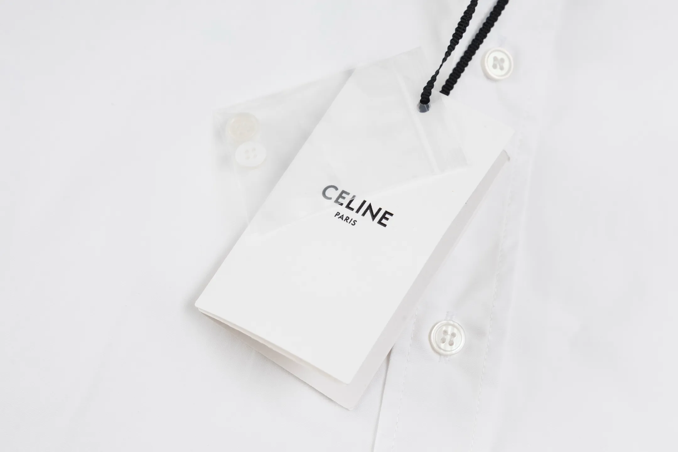 🅿️420 [Exclusive supply] Celine Arc de Triomphe small label hem long-sleeved shirt. The fabric is made of high-count cotton yarn with a high warp density and low weft density weaving process, which is light and has excellent breathability. The surface is smooth and flat, and feels as smooth as silk. At the same time, it retains the natural skin-friendly properties of cotton, making it snug and comfortable without any strange feeling. Because the warp yarns are closely arranged, the surface of the fabric shows longitudinal texture and soft luster, enhancing the visual sense of luxury. The single-color flat embroidery on the front panel uses the high-precision calculation system of the computer embroidery machine to control the coordinated operation of the machine head, needle bar, and thread spool. The fabric frame moves accurately in the horizontal and vertical directions to form a stitch track. The upper and lower thread tensions are adjusted to ensure that the stitches are smooth and free of floating threads, forming a fine pattern with an error of ±0.1mm. The ironer turns the collar up, irons it from the bottom to the top using high-temperature, moist steam, applies pressure to smooth out the wrinkles, and then turns it over to the front and repeats the process. Turn to the neckline and iron it into an arc shape, and press the back neckline to the bottom to keep it straight. The rotator cuff part uses the hanging method to avoid crushing the edges. After adjusting the fiber density through the ironer's "push, return, and pull" technology, the shirt can better fit the body curve Size: 46-48-50-52
