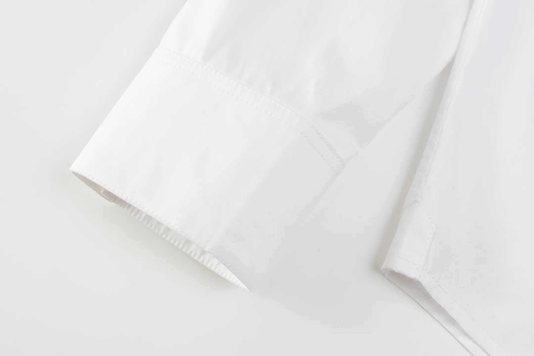 🅿️420 [Exclusive supply] Celine Arc de Triomphe small label hem long-sleeved shirt. The fabric is made of high-count cotton yarn with a high warp density and low weft density weaving process, which is light and has excellent breathability. The surface is smooth and flat, and feels as smooth as silk. At the same time, it retains the natural skin-friendly properties of cotton, making it snug and comfortable without any strange feeling. Because the warp yarns are closely arranged, the surface of the fabric shows longitudinal texture and soft luster, enhancing the visual sense of luxury. The single-color flat embroidery on the front panel uses the high-precision calculation system of the computer embroidery machine to control the coordinated operation of the machine head, needle bar, and thread spool. The fabric frame moves accurately in the horizontal and vertical directions to form a stitch track. The upper and lower thread tensions are adjusted to ensure that the stitches are smooth and free of floating threads, forming a fine pattern with an error of ±0.1mm. The ironer turns the collar up, irons it from the bottom to the top using high-temperature, moist steam, applies pressure to smooth out the wrinkles, and then turns it over to the front and repeats the process. Turn to the neckline and iron it into an arc shape, and press the back neckline to the bottom to keep it straight. The rotator cuff part uses the hanging method to avoid crushing the edges. After adjusting the fiber density through the ironer's "push, return, and pull" technology, the shirt can better fit the body curve Size: 46-48-50-52