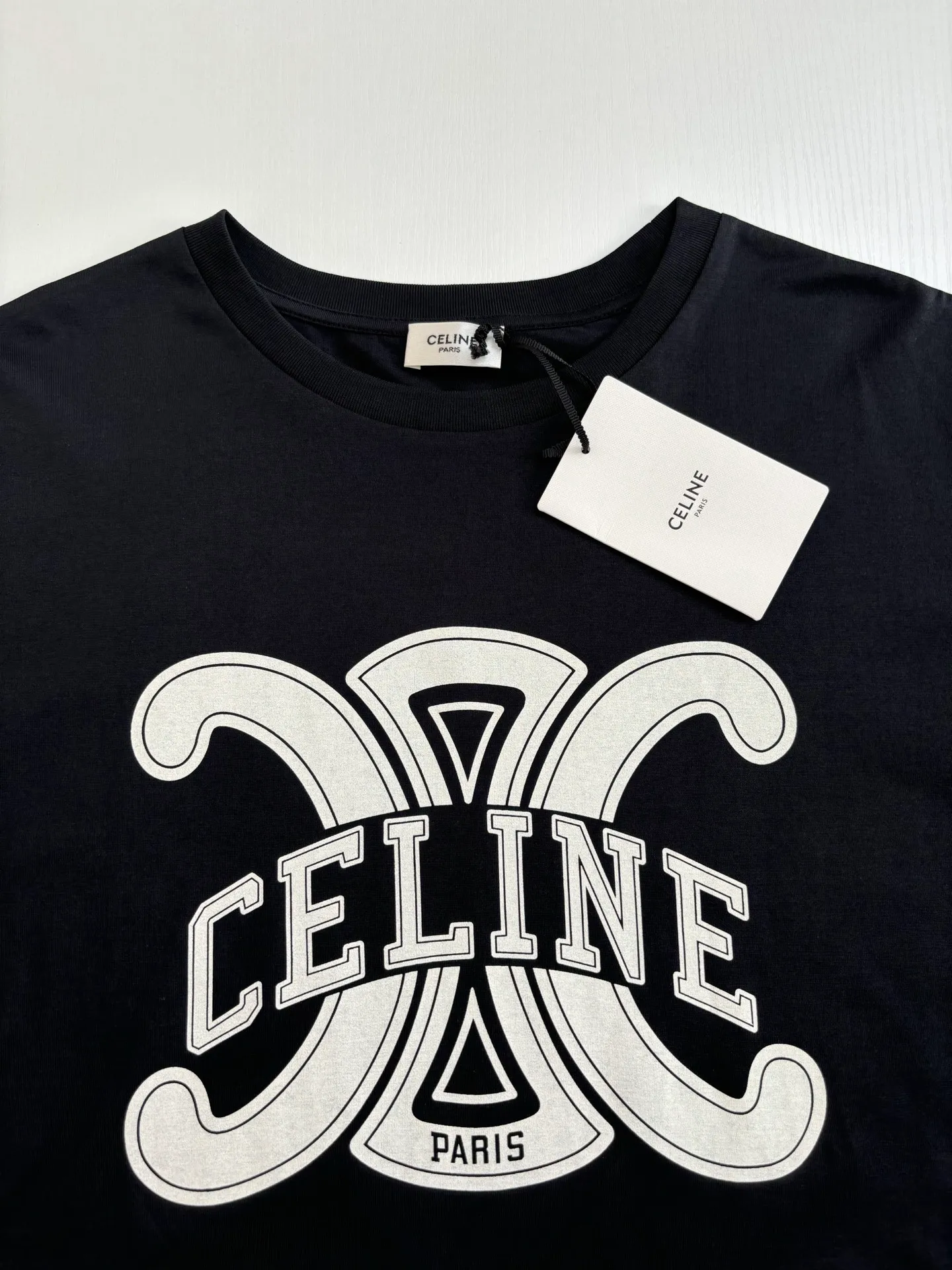 🅿️270 Celin*/Celin 25Ss new triumph button printed round neck short sleeves. Made of 50S double-strand mercerized cotton, weight 165g; with 32S 1×1 pull thread, 260g. The finer the yarn and the higher the count, the softer, smoother and finer the resulting fabric is usually. Two yarns are used and twisted together. Doing so can enhance the strength and durability of the fabric and give it a fuller feel. Cotton fibers are treated with concentrated caustic soda solution to smooth the fiber surface and increase the gloss and softness of the fabric.  Size：XS/S/M/L