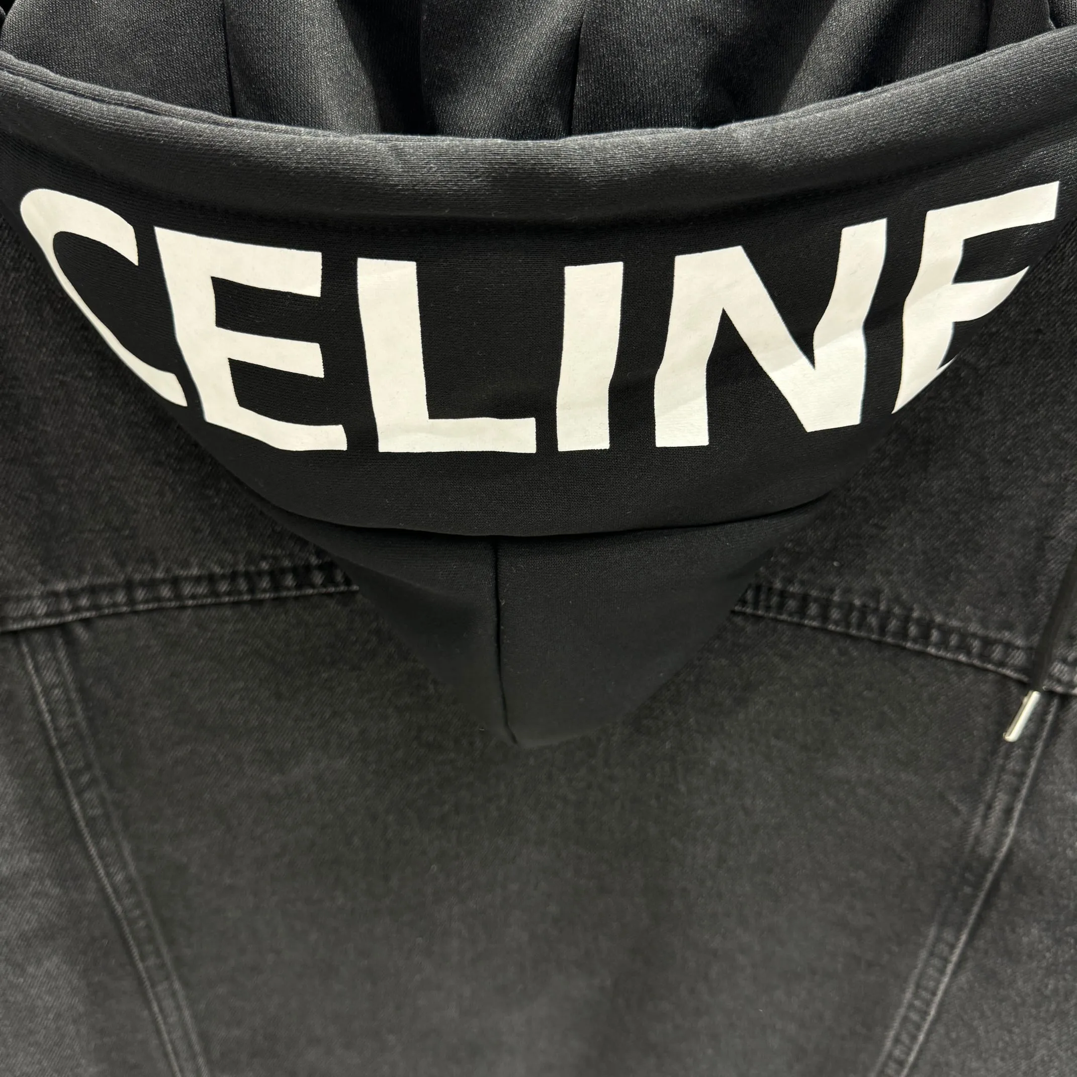 🅿️350 Celin 2025 new fake two-piece denim jacket with hood, denim and sweatshirt spliced ​​together, it has a bit of a student-era atmosphere! The hat is printed with the logo of the capsule series and is not removable. The fake two-piece design feels great and is very easy to match. It can be worn in all seasons! The whole piece of clothing uses multiple washing techniques, including fermentation washing + fermentation grinding + horsetail + cat whiskers. The fabric is pure cotton denim with bamboo. The feel is almost the same as YB, so it is more expensive than regular ones! Many places on the clothes are whitened and polished, and the light and dark are intertwined to enhance the freshness of the clothes, unlike the dull and boring colors of a single color. The hardware I-buckle is molded and customized, and the details are very good! Size M L XL XXL Color Black