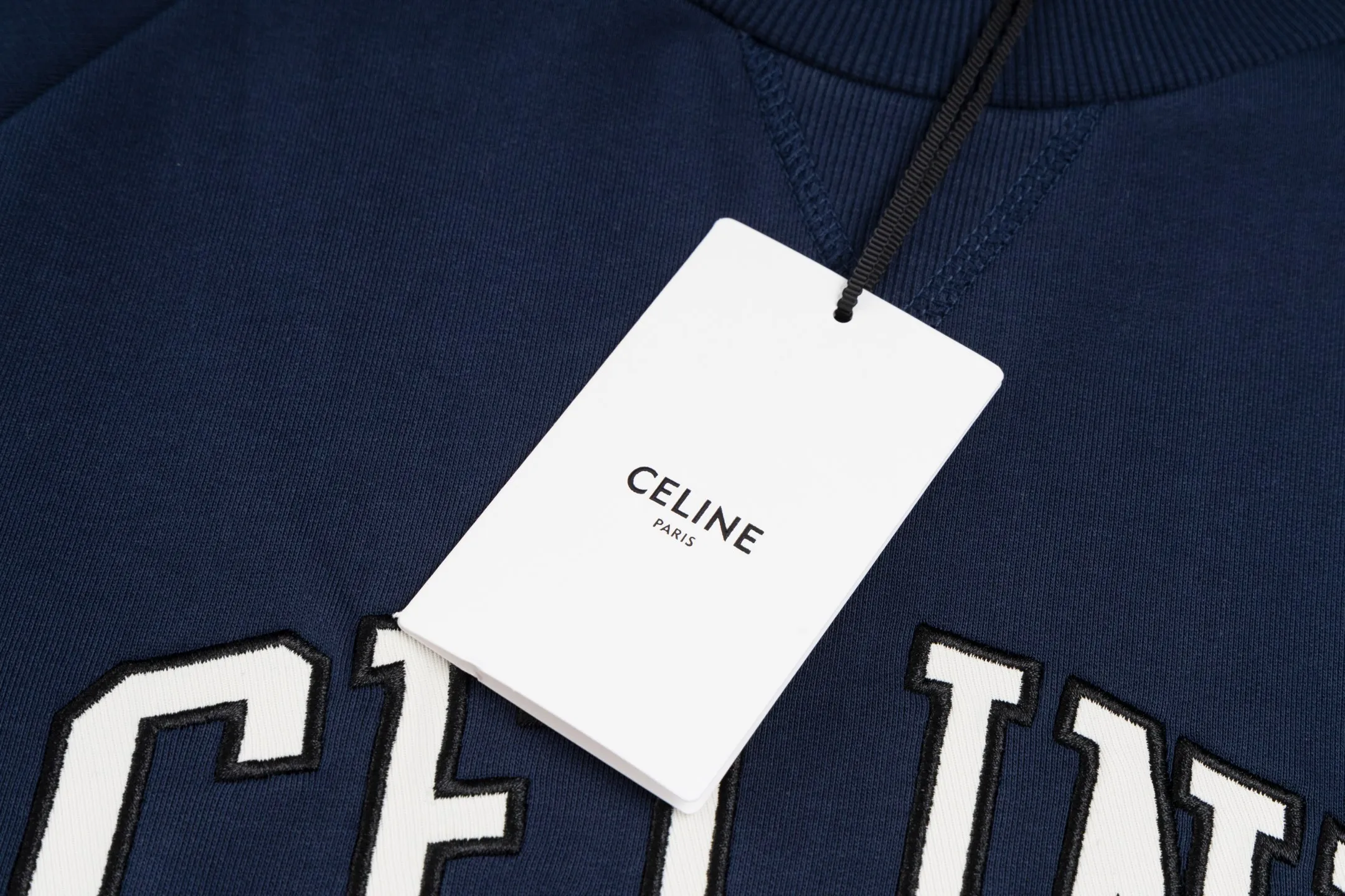 🅿️420 [Exclusive supply] Celine 25FW stroke patch letter round neck sweatshirt. The fabric is made of 26S 380g double yarn + 10S reverse terry bottom yarn fabric, and the rib is made of 21S 380g double yarn rib. The fabric structure adopts a unique 26S/10S double yarn system: the surface is woven with 26 fine yarns to ensure a delicate skin feel and a smooth appearance; the inside is made of 10 roving yarns to form a rich and waxy terry, which is fluffy and soft after being raised. The combination of two different materials achieves a balance between warmth retention and breathability. The core craftsmanship is reflected in the patch embroidery decoration, where the custom-shaped patch is accurately positioned and then covered with high-density embroidery thread for hemming. This process makes the pattern present a strong three-dimensional layering, and the edges are strong and wear-resistant, effectively avoiding the problem of easy snagging in ordinary embroidery, and at the same time improving the visual expression through material collision. The design follows the classic raglan sleeve structure, and the sleeves are seamlessly connected to the body, giving the shoulders greater freedom of movement. The V-shaped ribbed round neck not only enhances the collar's resistance to deformation with counter-directional weaving, but also optimizes the visual proportions of the neck and face through line extension. The overall design is constructed through the triple combination of composite weaving, heavy embroidery and functional patterns to create an extraordinary design style in the basic style. Size:XS-S-M-L