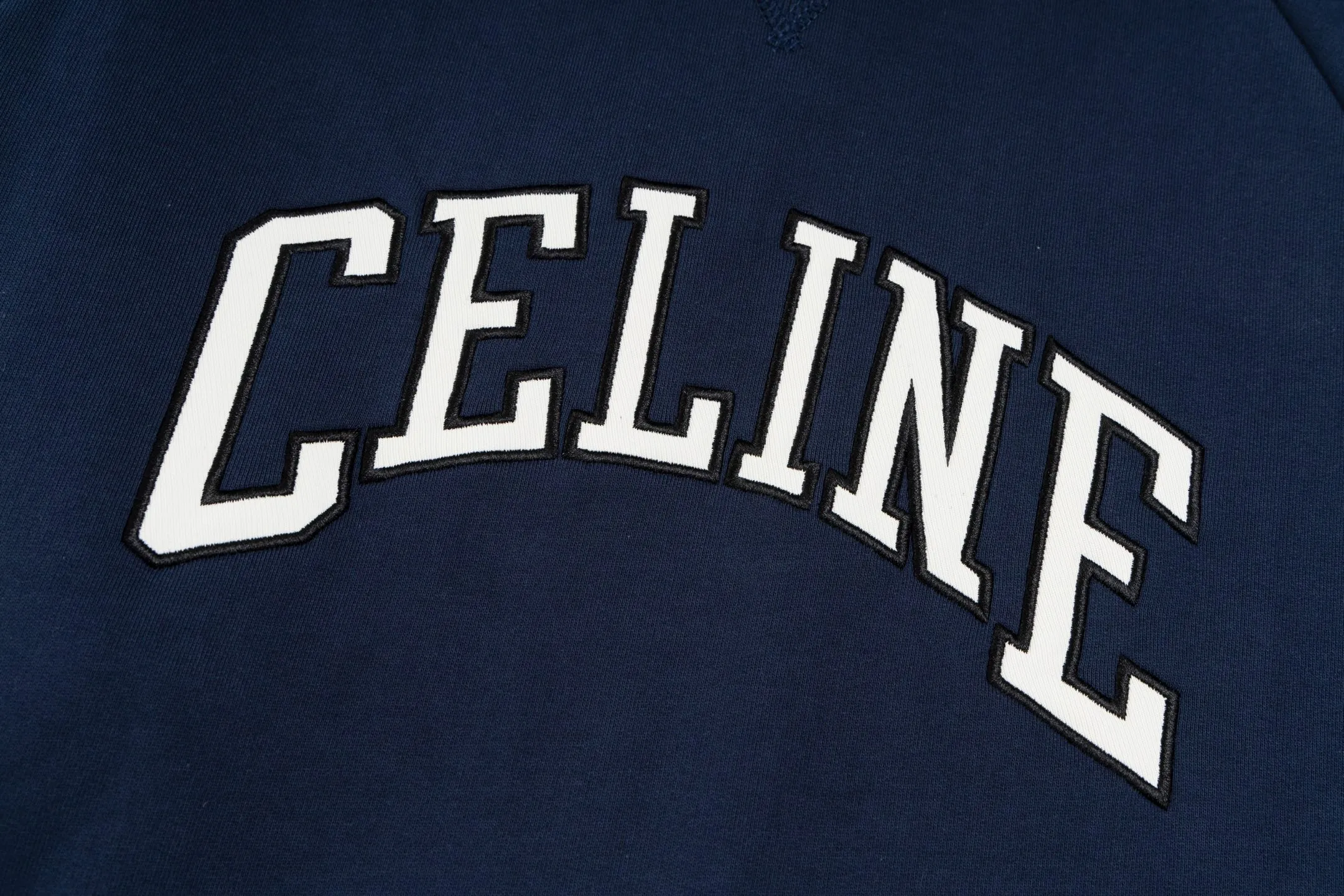 🅿️420 [Exclusive supply] Celine 25FW stroke patch letter round neck sweatshirt. The fabric is made of 26S 380g double yarn + 10S reverse terry bottom yarn fabric, and the rib is made of 21S 380g double yarn rib. The fabric structure adopts a unique 26S/10S double yarn system: the surface is woven with 26 fine yarns to ensure a delicate skin feel and a smooth appearance; the inside is made of 10 roving yarns to form a rich and waxy terry, which is fluffy and soft after being raised. The combination of two different materials achieves a balance between warmth retention and breathability. The core craftsmanship is reflected in the patch embroidery decoration, where the custom-shaped patch is accurately positioned and then covered with high-density embroidery thread for hemming. This process makes the pattern present a strong three-dimensional layering, and the edges are strong and wear-resistant, effectively avoiding the problem of easy snagging in ordinary embroidery, and at the same time improving the visual expression through material collision. The design follows the classic raglan sleeve structure, and the sleeves are seamlessly connected to the body, giving the shoulders greater freedom of movement. The V-shaped ribbed round neck not only enhances the collar's resistance to deformation with counter-directional weaving, but also optimizes the visual proportions of the neck and face through line extension. The overall design is constructed through the triple combination of composite weaving, heavy embroidery and functional patterns to create an extraordinary design style in the basic style. Size:XS-S-M-L