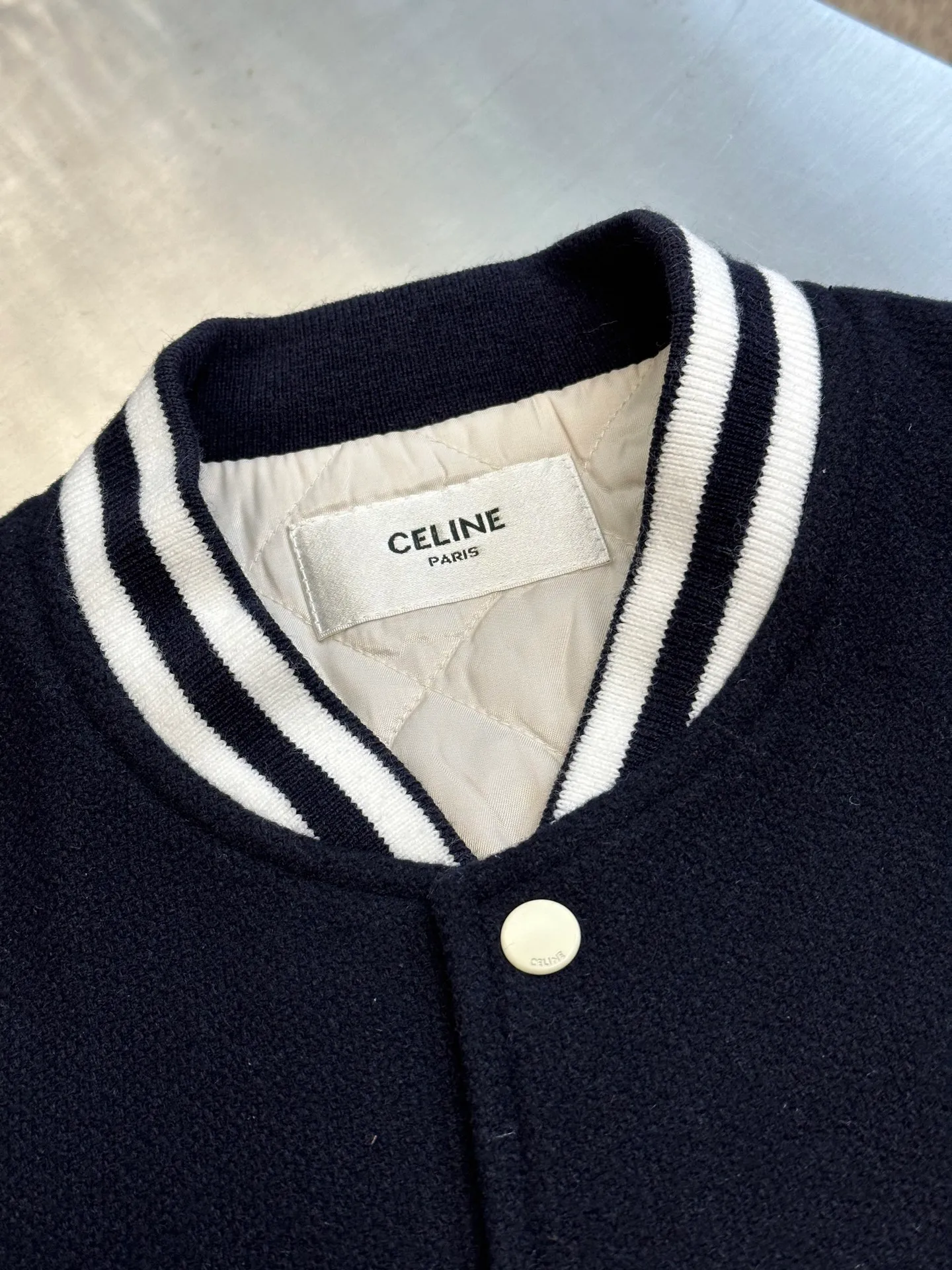 🅿️1800 Celine leather lettered baseball jersey. The fabric is made of 50% wool + 50% acrylic blended yarn, thick wool blended yarn, rapier machine-dyed rice grain jacquard pattern, weight 600g, matching rayon cotton 4*4 diamond checkered lining, using No. 800 washed cotton One-inch 9-needle spacing quilted embroidery, sleeve pocket lip + front and rear chapters are all made of fetal sheepskin, spray-painted according to the original color, the front chapter is laser-burned to create a leather patch, and the inside is filled with sponge embroidery machine embroidery, the back chapter is filled with silicone material inside the leather wool sample, electric hydraulic device Three-dimensional embossing, single letter punched out by letter die, hand-oiled edge sealing, hand-sweeping powder to position letter spacing, pattern machine thick line carving of letters, ribbing made of 30% wool + 70% cotton blended yarn, inter-color jacquard yarn-dyed, matching CE letters with matching round snap buttons.  size:36.38.40.42
