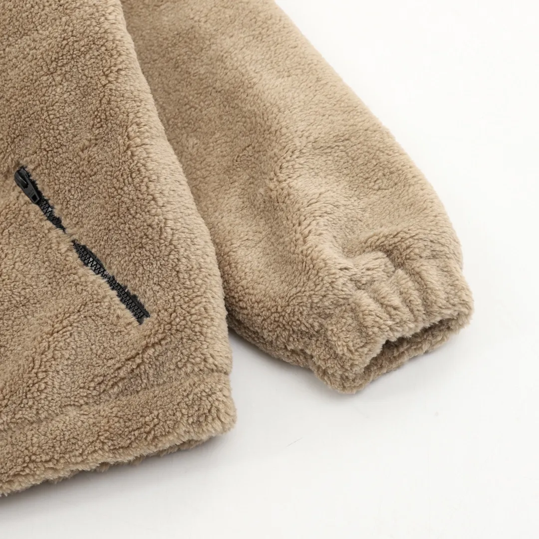 🅿️570 CELINE Arc de Triomphe Suede Cotton Jacket The polyester filament is passed through a circular knitting machine, and the warp and weft yarns are woven into each other into a double-sided knitted structure. The front and back are flat loops. The polar fleece fabric is formed after a series of processes such as dyeing, raising, carding, shearing, and polarization. The suede texture is soft and the fiber characteristics make it almost non-absorbent. It can quickly drain sweat to the outer layer of the fabric and evaporate quickly, maintaining good breathability. The suede surface can lock the air and form a stagnant air layer around the body, effectively preventing heat loss and providing good warmth retention properties. Using quilted cannage pattern, the seamstress precisely adjusts the speed of the machine and stitch density, so that the stitches are smooth and even during the operation. After completion, regular diagonal quilting lines will be formed, which will inadvertently enhance the overall texture when putting it on and taking it off. The fabric and padding material are tightly fixed to the frame of the embroidery machine. The embroidery machine uses sparse stitches along the padding layer's pattern to outline the filling area of ​​the pattern, and then runs the overlay layer's pattern, using dense stitches to perfectly cover the foam padding layer, thus forming a slightly raised Arc de Triomphe shape. After final finishing, the edges of the patch are burr-free and the pattern is clear. Size：XS-L