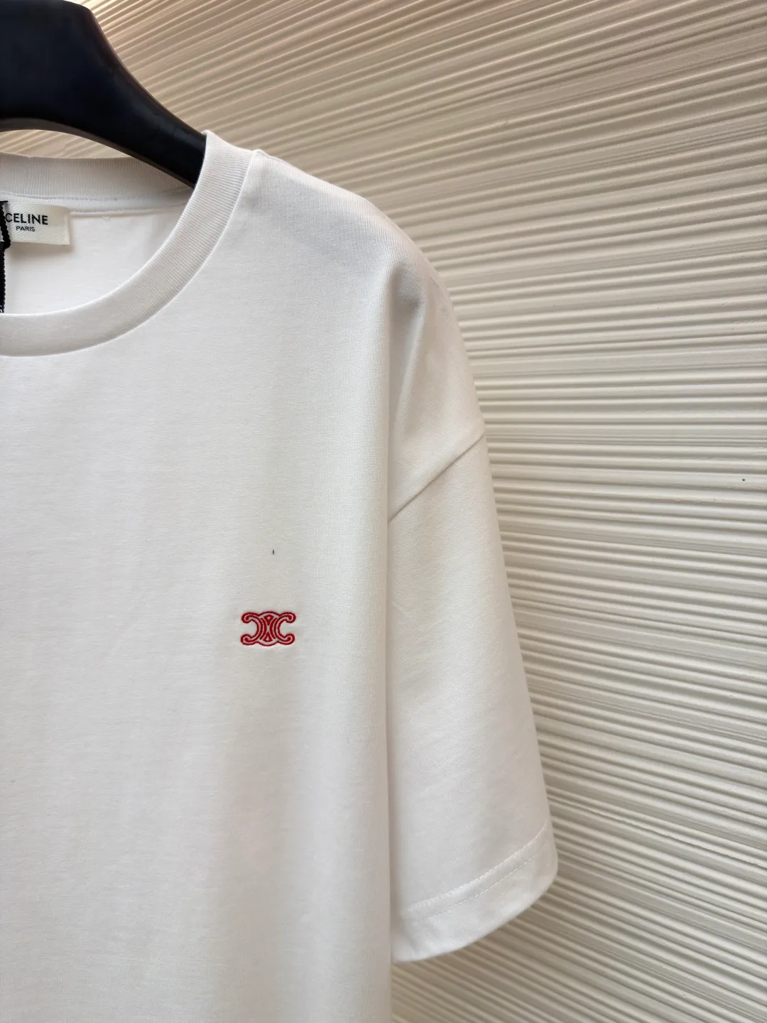 Celine Arc de Triomphe logo short sleeves ●Item number: 1682387-A00 ●Material: cotton fabric ●Technology: embroidery production ●Color: white ●Version: fitted version ●Weight: about 285 grams ●Size: XS-S-M-L ●Description: Made of 15-count special-spun compact cotton with a weight of 230g/㎡; 32-count high-weight (340g) 1x1 ribs are used for the neckline. Its high-count and high-weight characteristics ensure the excellent elastic recovery, thickness and deformation resistance of the collar. It is the key to ensuring that the neckline of the T-shirt does not deform after long-term wear. Specially woven compact cotton fabrics apply compact spinning technology in the spinning process, which effectively reduces yarn hairiness and makes the yarn smoother and stronger. This gives the fabric an unusually dense structure, a smooth and smooth surface, and excellent pilling resistance, while retaining the softness and breathability of pure cotton. The weight of 230g is medium to heavy, which ensures the T-shirt has good stiffness and drape, and is not easy to collapse and deform, laying a high-quality basic texture. The overall wiring is straight and delicate, the fabric is comfortable and soft, and the color is consistent without color difference. It can be matched with the same style to create a fashionable look and control various occasions. Customized accessories, complete with three standards, same style for men and women!