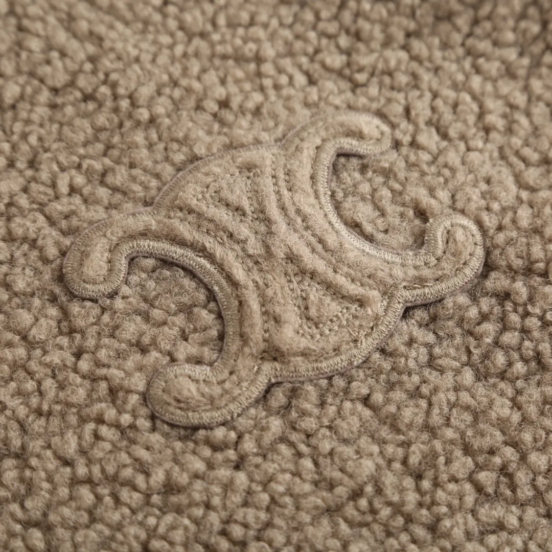 🅿️630 [Exclusive supply] Celine Arc de Triomphe lamb wool hooded jacket (khaki) The fabric is made of polyester filament and passed through a circular knitting machine. The warp and weft are woven into a double-sided knitted structure with flat loops on the front and back. The polar fleece fabric is formed after a series of processes such as dyeing, raising, carding, shearing, and polarization. The suede texture is soft and the fiber characteristics make it almost non-absorbent. It can quickly drain sweat to the outer layer of the fabric and evaporate quickly, maintaining good breathability. The suede surface can lock the air and form a stagnant air layer around the body, effectively preventing heat loss and providing good warmth retention properties. The inner quilting uses a quilted cannage pattern. The sewing engineer accurately adjusts the machine's speed and stitch density to ensure smooth and even stitches during the operation. After completion, regular diagonal quilting lines will be formed, which will inadvertently enhance the overall texture when putting it on and taking it off. The fabric and padding material are tightly fixed to the frame of the embroidery machine. The embroidery machine uses sparse stitches along the padding layer's pattern to outline the filling area of ​​the pattern, and then runs the overlay layer's pattern, using dense stitches to perfectly cover the foam padding layer, thus forming a slightly raised Arc de Triomphe shape. After final finishing, the edges of the patch are burr-free and the pattern is clear. Size:S-M-L-XL