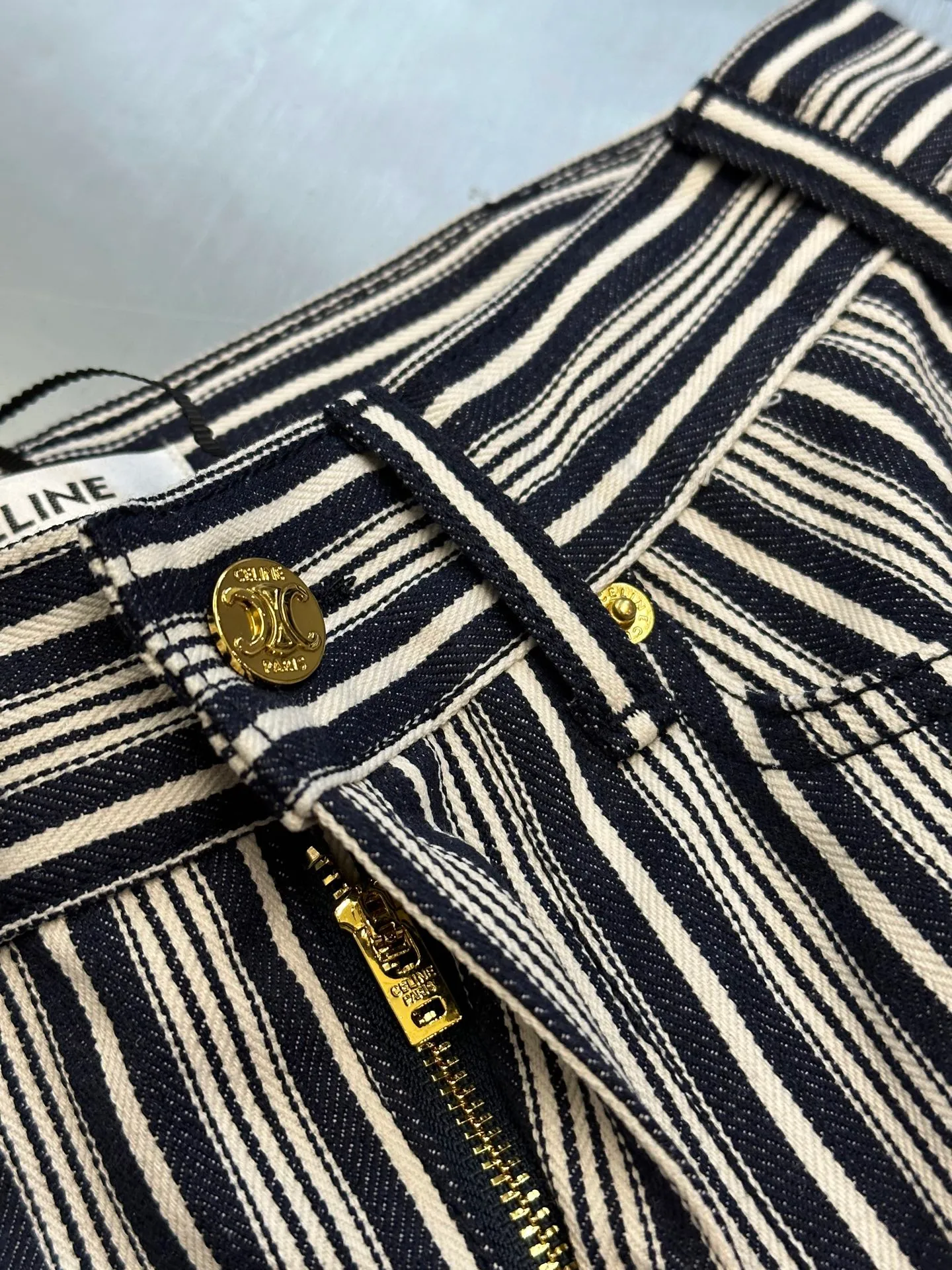 🅿️500 Celine striped straight trousers. These CELINE striped jeans cleverly combine retro elegance with modern street style. The crisp and stylish straight-leg trousers are matched with navy blue and off-white pinstripe texture, which visually makes the legs more slender. The golden metal buttons and zipper pullers on the front are engraved with the CELINE brand logo, showing exquisite style in the details.  The waistband adopts a classic five-pocket design, and the front and rear pockets are equipped with metal rivets, which combines practicality and design. The trousers are made of thick and crisp high-quality denim cotton. The fabric has a three-dimensional and clear texture. It is both durable and more textured. It is suitable for daily commuting or urban casual wear.  size：s m l