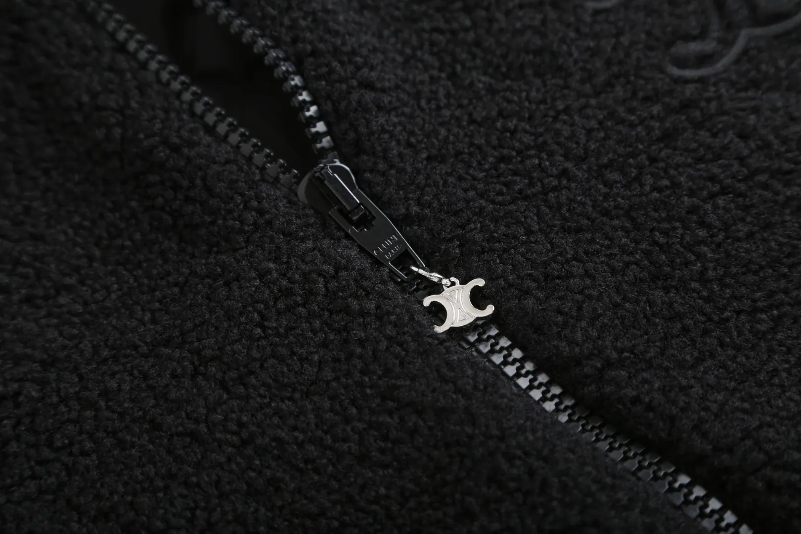 🅿️630 [Exclusive supply] Celine Arc de Triomphe lamb wool hooded jacket (black) The fabric is made of polyester filament and passed through a circular knitting machine. The warp and weft yarns are woven into each other into a double-sided knitted structure. The front and back are flat loops. The polar fleece fabric is formed after a series of processes such as dyeing, raising, carding, shearing, and polarization. The suede texture is soft and the fiber characteristics make it almost non-absorbent. It can quickly drain sweat to the outer layer of the fabric and evaporate quickly, maintaining good breathability. The suede surface can lock the air and form a stagnant air layer around the body, effectively preventing heat loss and providing good warmth retention properties. The inner quilting uses a quilted cannage pattern. The sewing engineer accurately adjusts the machine's speed and stitch density to ensure smooth and even stitches during the operation. After completion, regular diagonal quilting lines will be formed, which will inadvertently enhance the overall texture when putting it on and taking it off. The fabric and padding material are tightly fixed to the frame of the embroidery machine. The embroidery machine uses sparse stitches along the padding layer's pattern to outline the filling area of ​​the pattern, and then runs the overlay layer's pattern, using dense stitches to perfectly cover the foam padding layer, thus forming a slightly raised Arc de Triomphe shape. After final finishing, the edges of the patch are burr-free and the pattern is clear. Size:S-M-L-XL