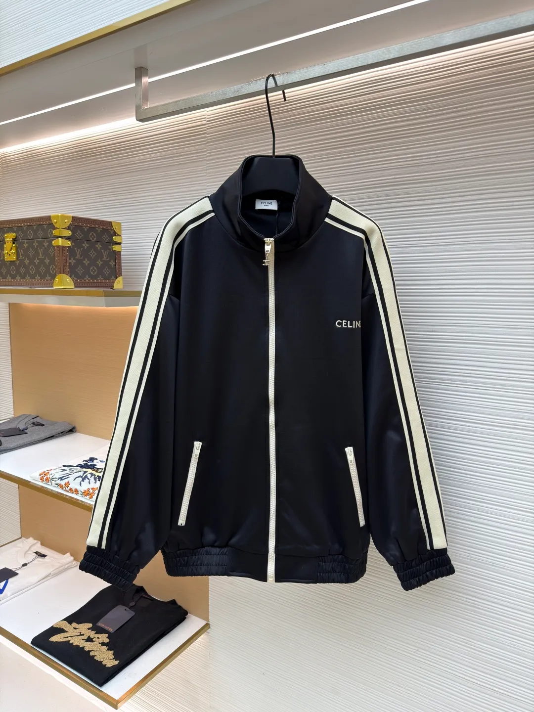 Celine side webbing splicing jacket ●Original version: Purchased and developed by 6909 ●Item number: 1681407-B70 ●Fabric: pure cotton fabric ●Technology: ribbon production ●Color: black ●Version: fitted version ●Weight: about 780 grams ●Size: XS-S-M-L ●Description: This jacket is made of high-quality smooth fabric, with a crisp texture and good drape. The stand-up collar design is equipped with a metal zipper, which is smooth and durable, and easy to open and close. The white stripes on the side of the sleeves are made of precision splicing technology, which naturally connects with the black body, and the lines are straight and smooth. The "CELINE" brand logo on the body is three-dimensional embroidery, the stitching is fine and even, and the brand is highly recognizable. The pockets on both sides are equipped with zippers, which are practical and enhance the overall texture. The rib design on the cuffs and hem has excellent elasticity and fits the body shape. From fabric selection to embroidery, splicing and zipper craftsmanship, every detail demonstrates the brand's strict control over quality, integrating sports style with high-end fashion craftsmanship, with both practicality and fashion. The overall wiring is straight and delicate, the fabric is comfortable and soft, and the color is consistent without color difference. It can be matched with the same style to create a fashionable look and control various occasions. Customized accessories, complete with three standards, same style for men and women!