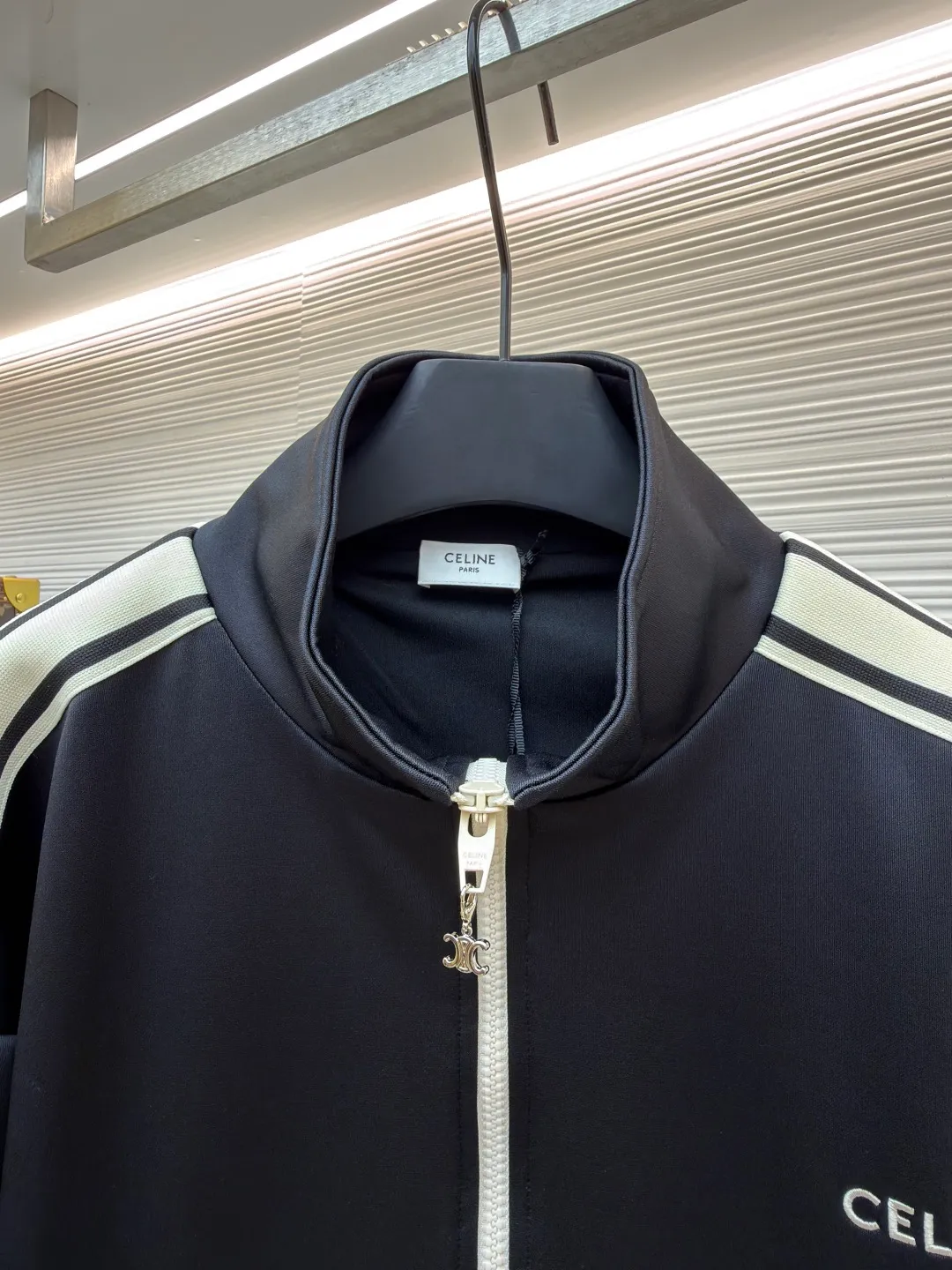 Celine side webbing splicing jacket ●Original version: Purchased and developed by 6909 ●Item number: 1681407-B70 ●Fabric: pure cotton fabric ●Technology: ribbon production ●Color: black ●Version: fitted version ●Weight: about 780 grams ●Size: XS-S-M-L ●Description: This jacket is made of high-quality smooth fabric, with a crisp texture and good drape. The stand-up collar design is equipped with a metal zipper, which is smooth and durable, and easy to open and close. The white stripes on the side of the sleeves are made of precision splicing technology, which naturally connects with the black body, and the lines are straight and smooth. The "CELINE" brand logo on the body is three-dimensional embroidery, the stitching is fine and even, and the brand is highly recognizable. The pockets on both sides are equipped with zippers, which are practical and enhance the overall texture. The rib design on the cuffs and hem has excellent elasticity and fits the body shape. From fabric selection to embroidery, splicing and zipper craftsmanship, every detail demonstrates the brand's strict control over quality, integrating sports style with high-end fashion craftsmanship, with both practicality and fashion. The overall wiring is straight and delicate, the fabric is comfortable and soft, and the color is consistent without color difference. It can be matched with the same style to create a fashionable look and control various occasions. Customized accessories, complete with three standards, same style for men and women!