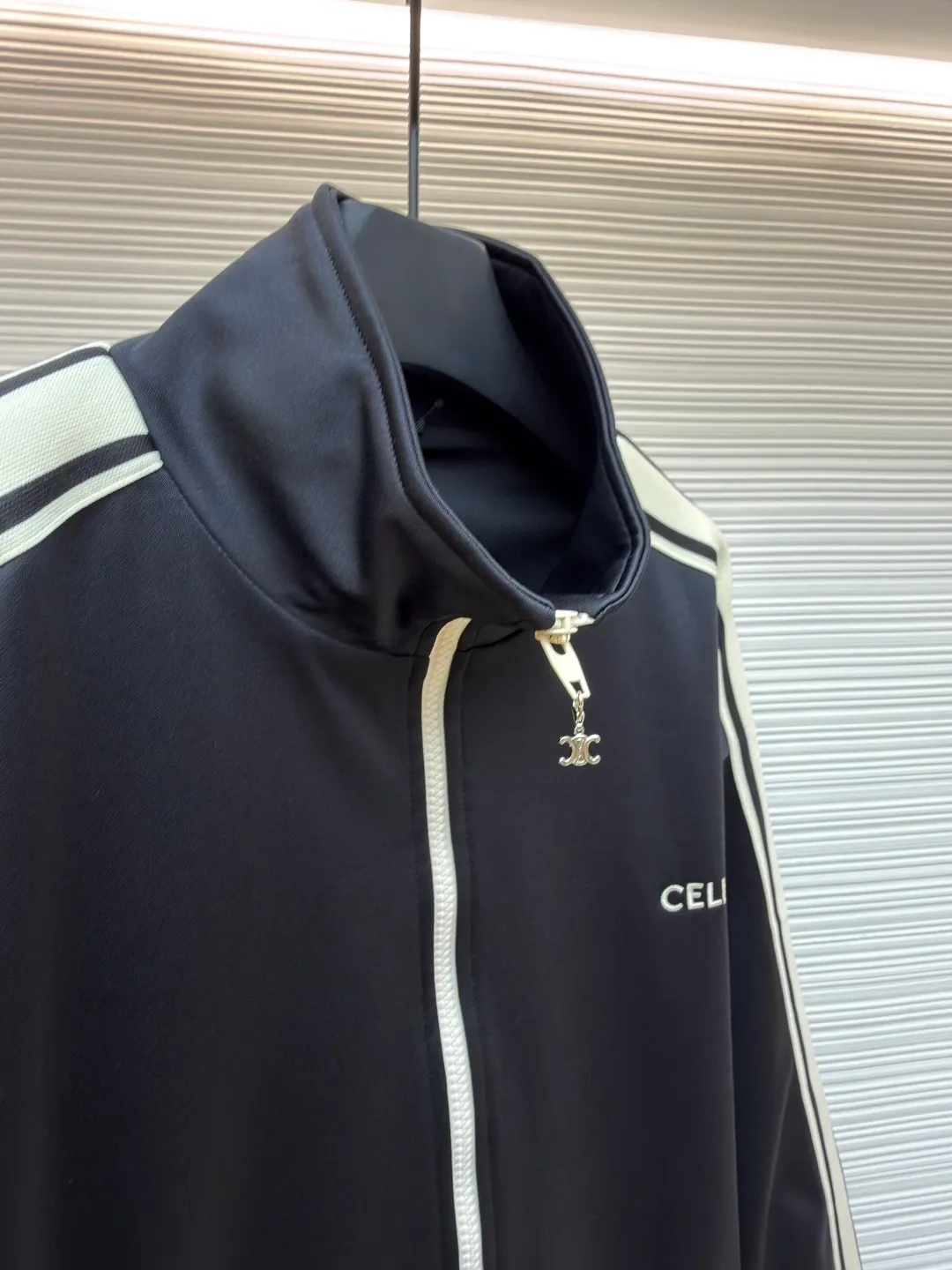 Celine side webbing splicing jacket ●Original version: Purchased and developed by 6909 ●Item number: 1681407-B70 ●Fabric: pure cotton fabric ●Technology: ribbon production ●Color: black ●Version: fitted version ●Weight: about 780 grams ●Size: XS-S-M-L ●Description: This jacket is made of high-quality smooth fabric, with a crisp texture and good drape. The stand-up collar design is equipped with a metal zipper, which is smooth and durable, and easy to open and close. The white stripes on the side of the sleeves are made of precision splicing technology, which naturally connects with the black body, and the lines are straight and smooth. The "CELINE" brand logo on the body is three-dimensional embroidery, the stitching is fine and even, and the brand is highly recognizable. The pockets on both sides are equipped with zippers, which are practical and enhance the overall texture. The rib design on the cuffs and hem has excellent elasticity and fits the body shape. From fabric selection to embroidery, splicing and zipper craftsmanship, every detail demonstrates the brand's strict control over quality, integrating sports style with high-end fashion craftsmanship, with both practicality and fashion. The overall wiring is straight and delicate, the fabric is comfortable and soft, and the color is consistent without color difference. It can be matched with the same style to create a fashionable look and control various occasions. Customized accessories, complete with three standards, same style for men and women!