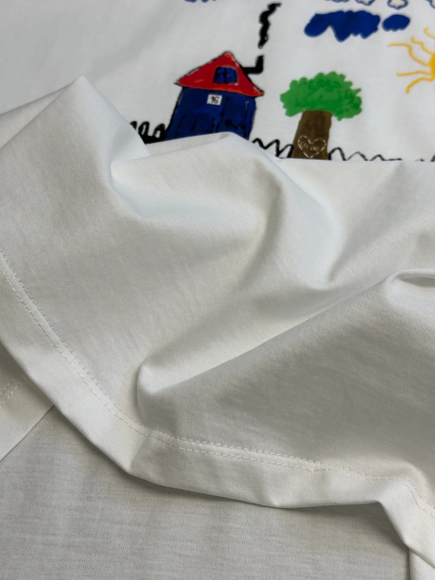 🅿️260 Celine childlike painting printed round neck short sleeves. Specific mercerized long-staple cotton fabric, made of 50S double-strand mercerized cotton, weight 165g; with 32S 1×1 tensioner thread, 300g. The finer the yarn and the higher the count, the softer, smoother and finer the resulting fabric is usually. Two yarns are used and twisted together. Doing so can enhance the strength and durability of the fabric and give it a fuller feel. Cotton fibers are treated with concentrated caustic soda solution to smooth the fiber surface and increase the gloss and softness of the fabric.  Childlike graffiti painting printing, according to the original color and the same color glue material, choose high-elastic stretch frame glue printing. It increases the elasticity of the printed area, and at the same time has strong penetration and color fastness, especially on cotton fabrics. The details of the printing are very well handled, with no burrs or traces of crossing the border. After technical processing of the printing screen, the slurry can penetrate into the fabric where there is a pattern. The permeability is strong and the fabric texture is clearly visible.  Dot paste printing technology is partially used. The distribution of dots is very dense, so the printed pattern has extremely high clarity and resolution. High-density dot paste printing technology is used to print various complex patterns and textures on clothing. Due to the special properties of the paste, the printed patterns have a certain degree of attraction, unique visual effects, and delicate touch.  Simple vertical round neck and short-sleeved version, the pattern is developed to create an extremely straight fit. The knitted material has certain stretchability, and the upper body will not be too tight. Round neck with ribbed splicing of the same color. The inner back collar is taped to effectively prevent the neckline from deforming after repeated wear and washing. The shoulder line is fitted, and the bottom hem and cuffs are trimmed with specially machined open-stitching.  size：xs s m l