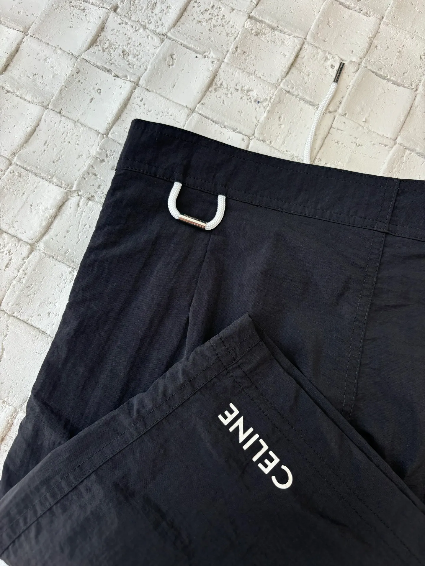 🅿️340 Celine*/Celine 25Ss new letter printed Bermuda shorts. The fabric is customized from nylon and has high elasticity and can quickly return to its original shape. This allows the nylon shorts to maintain comfort while also having better fit and mobility.  The offset printing process used on the hem uses screen printing technology. This technology engraves the pattern on the screen, and then presses the ink on the screen. The ink is pressed into the clothing fibers through pressure and extrusion to form the pattern. The brand LOGO is embellished with tones, the waist is equipped with an adjustable drawstring, and the metal hoop is engraved with CELINE PARIS Size: S/M/L/XL