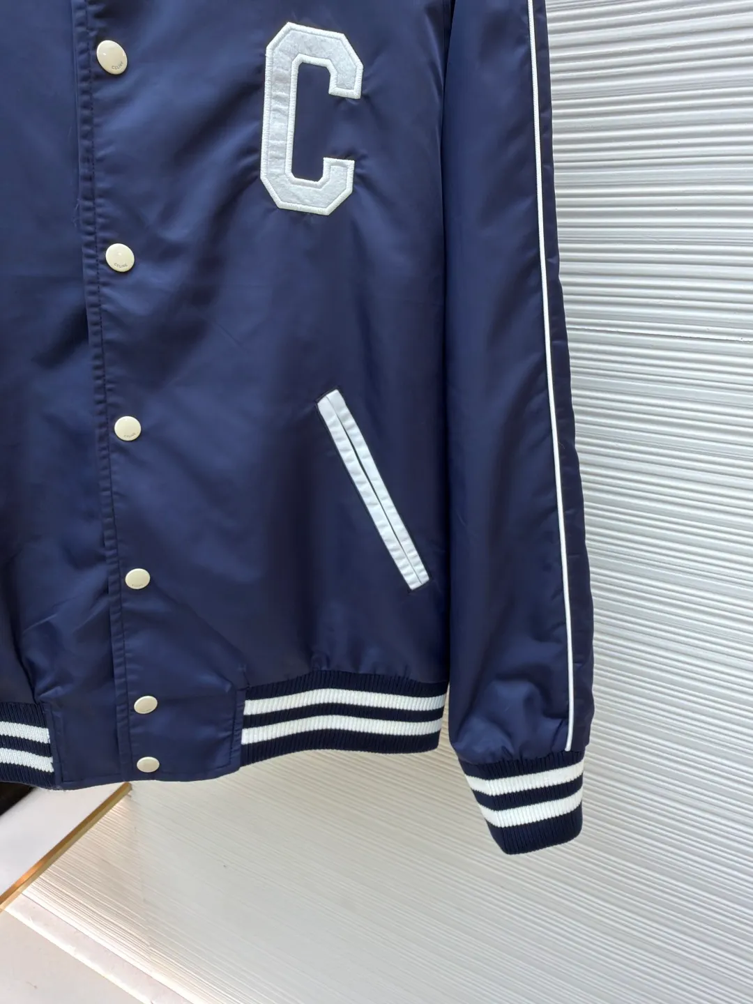 Celine college style baseball uniform ●Original version: Purchased and developed by 10213 ●Item number: 1680910-B90 ●Fabric: nylon fabric ●Technology: embroidery production ●Version: fitted version ●Weight: about 600 grams ●Size: 46-48-50-52 ●Description: This baseball uniform is made of blue satin nylon fabric. The front and back are designed with S's exclusive embroidery process. It has metal engraved four-button closures and a contrasting striped rib design on the hem and cuffs. The style is very novel and unique. It can be easily worn with T-shirts and jeans. It is the same style for men and women. Highly recommended! The overall wiring is straight and delicate, the fabric is comfortable and soft, and the color is consistent without color difference. It can be matched with the same style to create a fashionable look and control various occasions. Customized accessories, complete with three standards, same style for men and women!