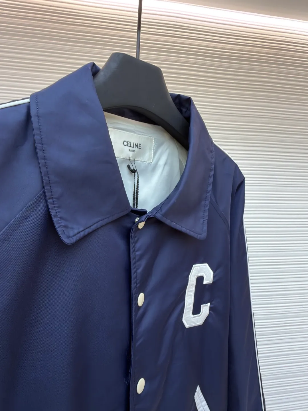 Celine college style baseball uniform ●Original version: Purchased and developed by 10213 ●Item number: 1680910-B90 ●Fabric: nylon fabric ●Technology: embroidery production ●Version: fitted version ●Weight: about 600 grams ●Size: 46-48-50-52 ●Description: This baseball uniform is made of blue satin nylon fabric. The front and back are designed with S's exclusive embroidery process. It has metal engraved four-button closures and a contrasting striped rib design on the hem and cuffs. The style is very novel and unique. It can be easily worn with T-shirts and jeans. It is the same style for men and women. Highly recommended! The overall wiring is straight and delicate, the fabric is comfortable and soft, and the color is consistent without color difference. It can be matched with the same style to create a fashionable look and control various occasions. Customized accessories, complete with three standards, same style for men and women!