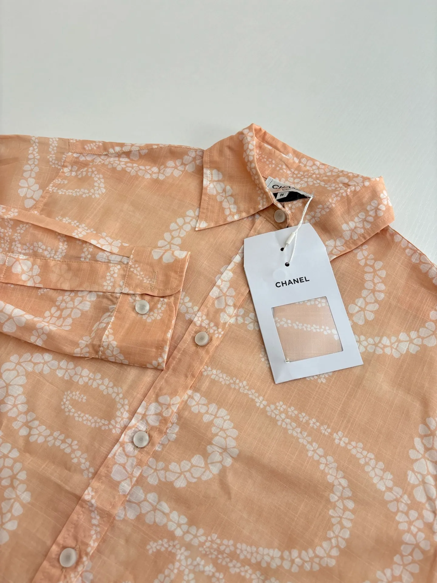 🅿️520 Chane*/Chanel Xiaoxiang 25coco beach resort series lapel shirt. Imported pure cotton fabric, textured and shiny, skin-nourishing and breathable. Lapel long-sleeved shirt, straight waist and loose fit. Tolerating the figure and adding free and easy handsomeness. The whole body is active and full of irregularly staggered camellia patterns. Interspersed with double C logos to highlight the brand style. Complex visual effects create a romantic and aesthetic style. Size: 36/38/40