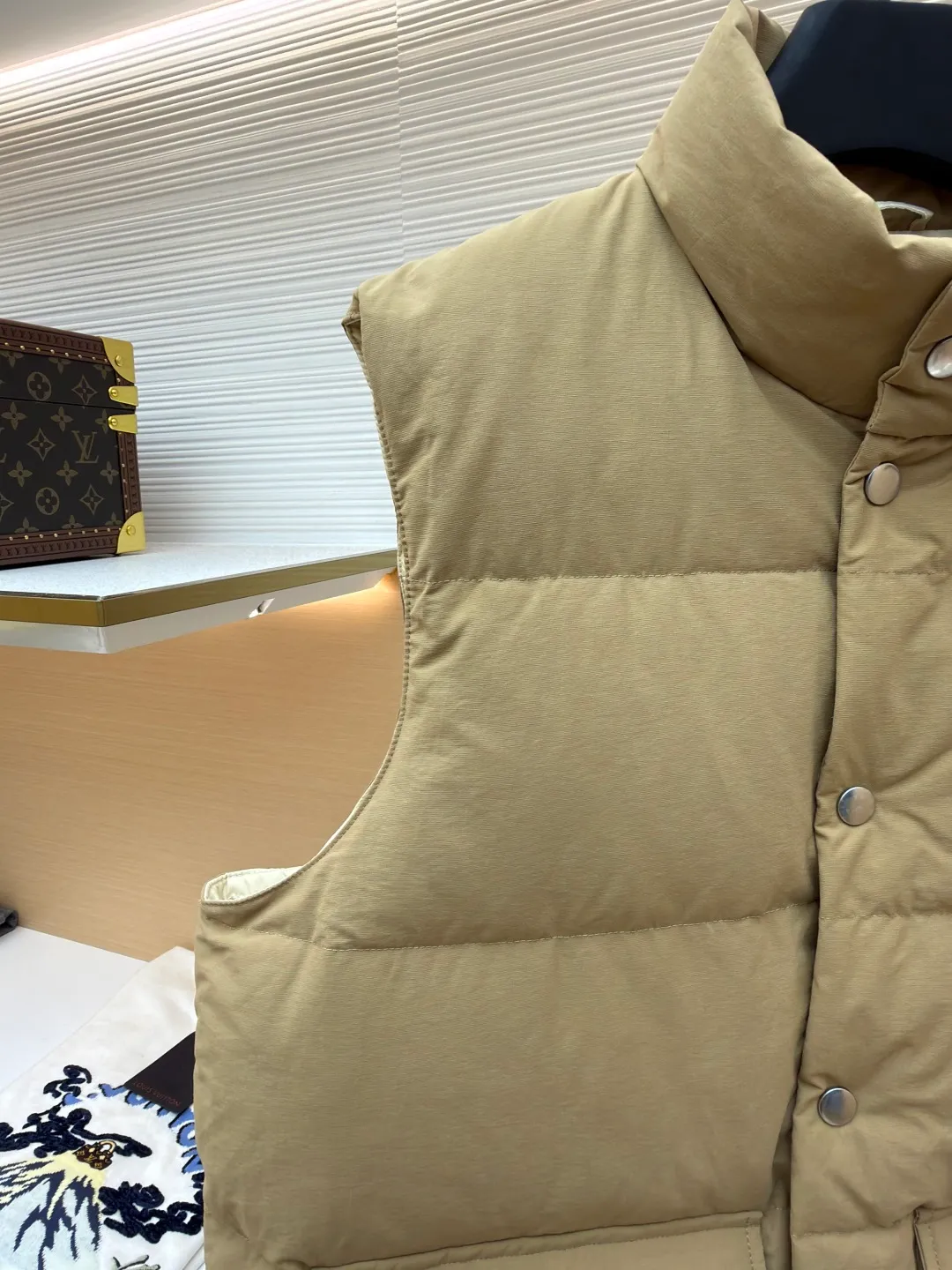 Prada stand collar badge down vest ●Original version: purchased and developed by 18756 ●Item number: 16801377-C30 ●Fabric: white duck down fabric ●Technology: mechanical down filling ●Color: khaki ●Version: Fitted version ●Weight: about 700 grams ●Size: S-M-L-XL ●Description: This vest is made of high-quality water-repellent fabric, and the khaki tone shows the texture. Using three-dimensional quilting technology, the down is evenly divided into full grid-shaped down-filled areas, which not only ensures warmth but also makes the silhouette crisp and three-dimensional. The neckline is designed with a stand-up collar and is matched with a metal snap placket, which is exquisite in texture and easy to put on and take off.  The front chest is decorated with the brand's iconic metal triangle logo, which is highly recognizable; the large patch pockets on both sides are three-dimensionally cut, and the bag mouth is in an inverted trapezoid shape, combining practicality and design. There is a built-in drawstring at the hem, and the tightness can be adjusted freely to suit different wear needs. From fabric selection to detail sewing, every process reflects the brand's strict control of craftsmanship, exquisitely integrating functionality and fashion sense. The overall wiring is straight and delicate, the fabric is comfortable and soft, and the color is consistent without color difference. It can be matched with the same style to create a fashionable look and control various occasions. Customized accessories, complete with three standards, same style for men and women!