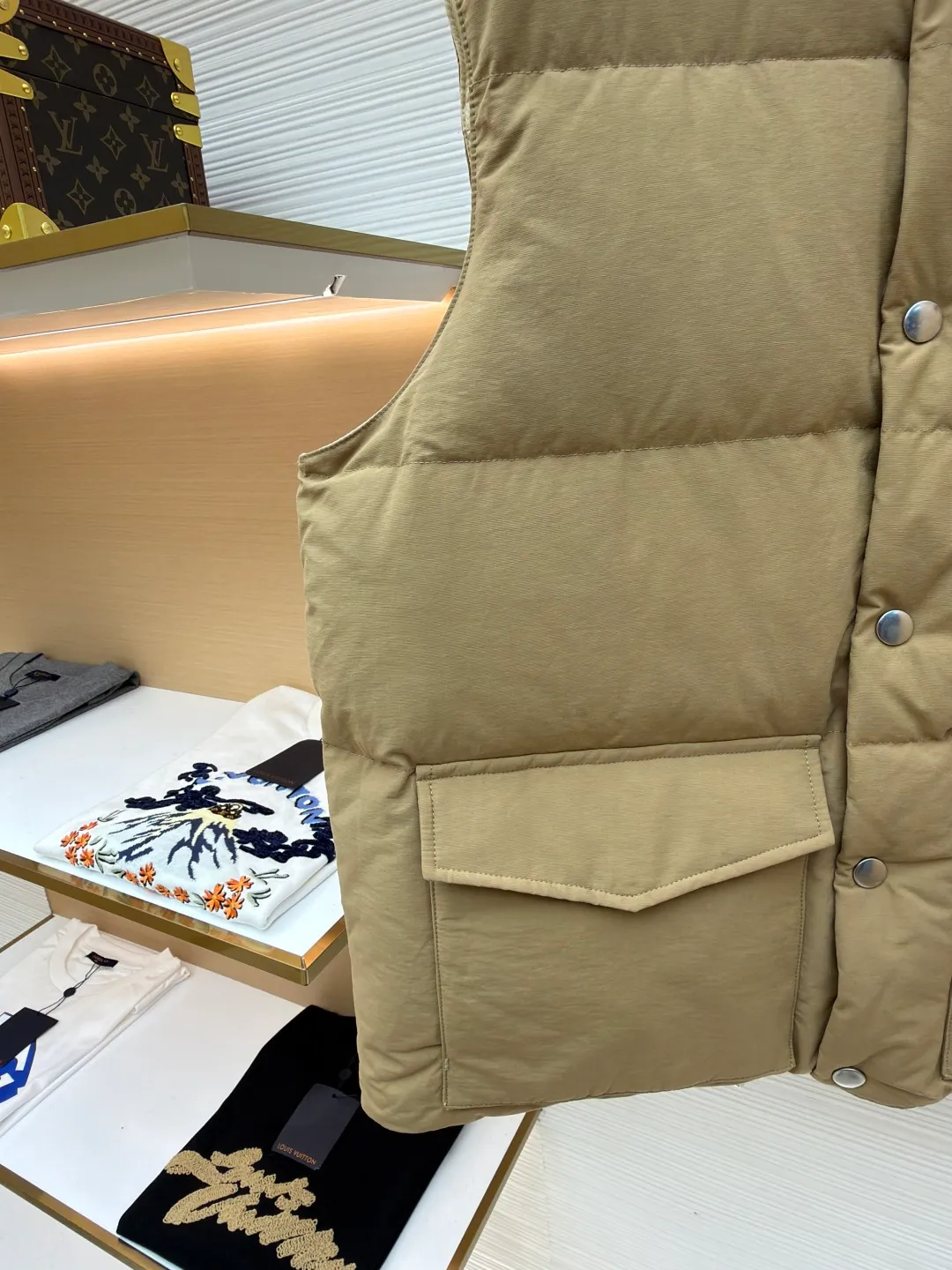 Prada stand collar badge down vest ●Original version: purchased and developed by 18756 ●Item number: 16801377-C30 ●Fabric: white duck down fabric ●Technology: mechanical down filling ●Color: khaki ●Version: Fitted version ●Weight: about 700 grams ●Size: S-M-L-XL ●Description: This vest is made of high-quality water-repellent fabric, and the khaki tone shows the texture. Using three-dimensional quilting technology, the down is evenly divided into full grid-shaped down-filled areas, which not only ensures warmth but also makes the silhouette crisp and three-dimensional. The neckline is designed with a stand-up collar and is matched with a metal snap placket, which is exquisite in texture and easy to put on and take off.  The front chest is decorated with the brand's iconic metal triangle logo, which is highly recognizable; the large patch pockets on both sides are three-dimensionally cut, and the bag mouth is in an inverted trapezoid shape, combining practicality and design. There is a built-in drawstring at the hem, and the tightness can be adjusted freely to suit different wear needs. From fabric selection to detail sewing, every process reflects the brand's strict control of craftsmanship, exquisitely integrating functionality and fashion sense. The overall wiring is straight and delicate, the fabric is comfortable and soft, and the color is consistent without color difference. It can be matched with the same style to create a fashionable look and control various occasions. Customized accessories, complete with three standards, same style for men and women!