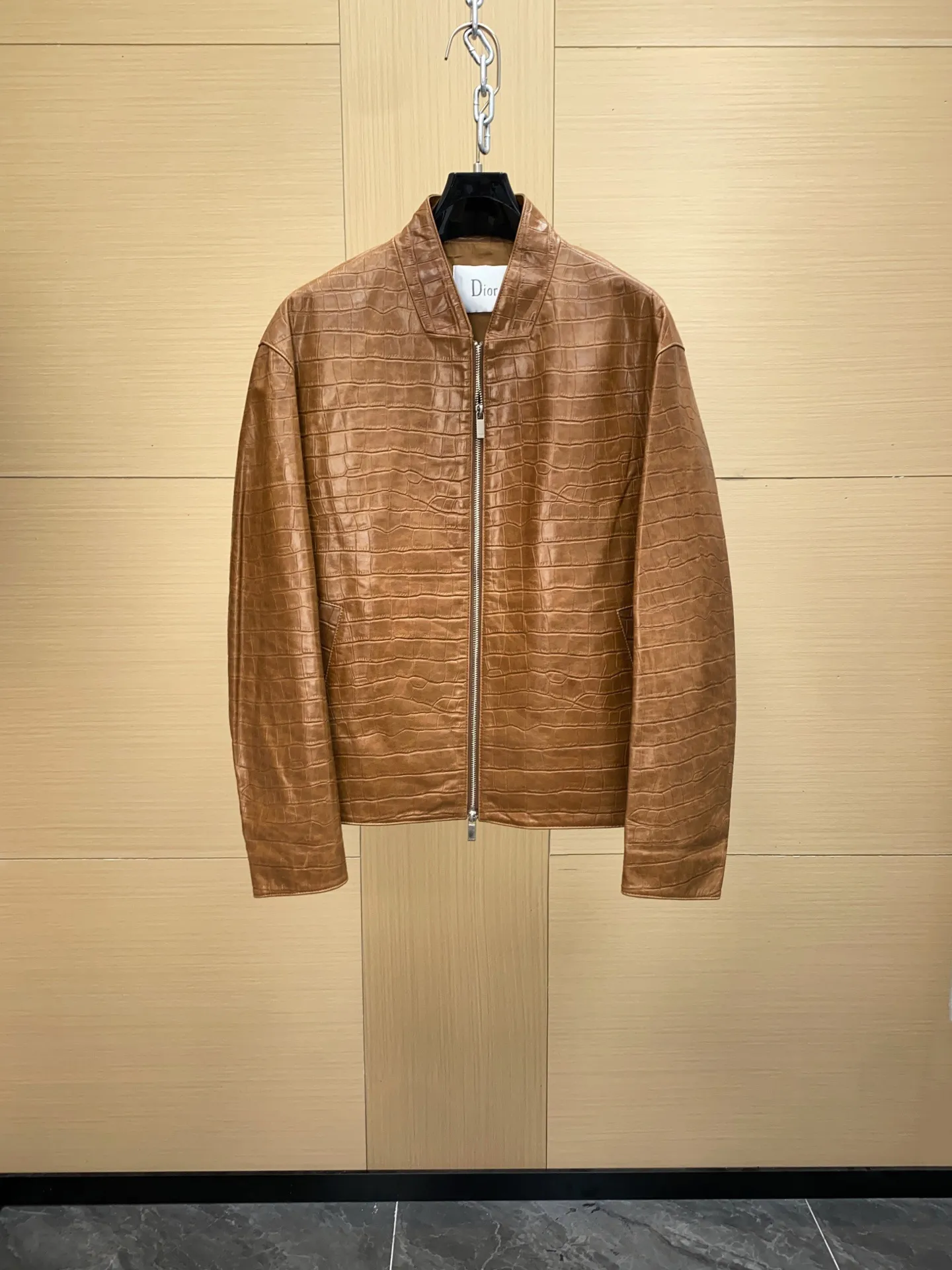 🅿️3060 DIOR Dior's new men's sheepskin jacket for autumn and winter 2025, reshaping autumn and winter style. On the fashion stage, Dior has always been the trend leader. In the autumn and winter of 2025, Dior's new men's sheepskin jacket makes a shocking debut, bringing the ultimate experience to men who pursue quality and style.   The jacket is made of imported brown sheepskin. Its unique color is deep and full of charm, like an elegant poem that has accumulated over time, highlighting the mature and stable temperament of men. This high-quality sheepskin not only looks charming, but also feels soft and delicate. Every time you touch it, you can feel the luxurious texture brought by the top material. It also has good breathability and wear resistance, ensuring that it is comfortable to wear in various occasions.   The design with crocodile print all over the body is the finishing touch. The crocodile pattern symbolizes strength and wildness, injecting unique fashion tension into the jacket, making the wearer stand out from the crowd. Every texture has been carefully suppressed, delicate and clear, showing a lifelike three-dimensional effect, interpreting Dior's persistent pursuit of craftsmanship.   The short version is a precise grasp of modern fashion. It breaks the traditional constraints and cleverly optimizes body proportions. Even men with average figures can instantly have a tall and straight posture when wearing it, showing a neat and capable temperament. Whether it is paired with a simple white T-shirt and jeans for casual daily use, or worn with a shirt and trousers for a business event, it can be perfectly adapted and can easily handle various occasions.   The new products of the season have arrived in the store. We sincerely invite you to try them out and experience the unique charm of Dior's new 2025 autumn and winter men's sheepskin jackets.  Code number: 48-56