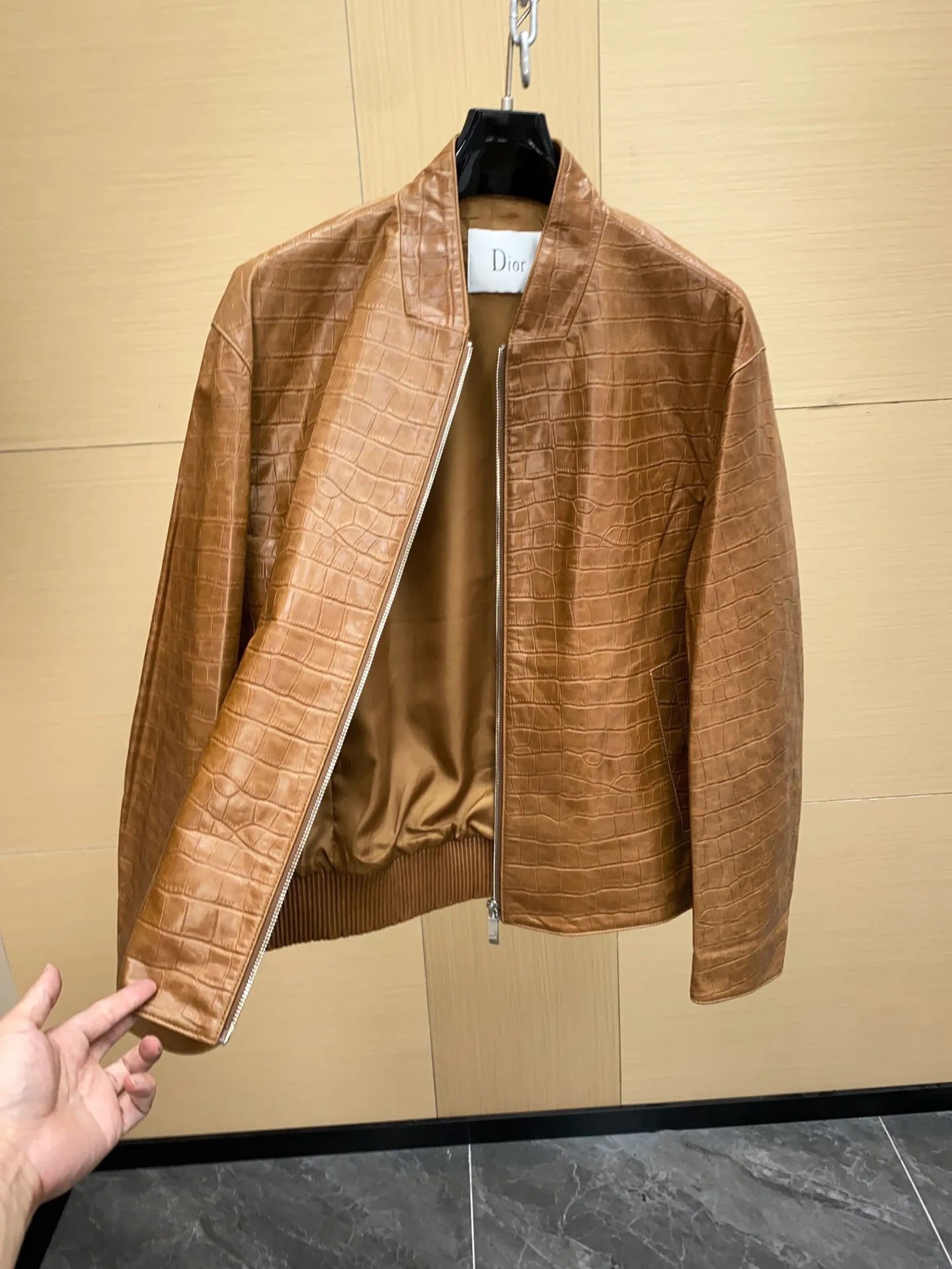 🅿️3060 DIOR Dior's new men's sheepskin jacket for autumn and winter 2025, reshaping autumn and winter style. On the fashion stage, Dior has always been the trend leader. In the autumn and winter of 2025, Dior's new men's sheepskin jacket makes a shocking debut, bringing the ultimate experience to men who pursue quality and style.   The jacket is made of imported brown sheepskin. Its unique color is deep and full of charm, like an elegant poem that has accumulated over time, highlighting the mature and stable temperament of men. This high-quality sheepskin not only looks charming, but also feels soft and delicate. Every time you touch it, you can feel the luxurious texture brought by the top material. It also has good breathability and wear resistance, ensuring that it is comfortable to wear in various occasions.   The design with crocodile print all over the body is the finishing touch. The crocodile pattern symbolizes strength and wildness, injecting unique fashion tension into the jacket, making the wearer stand out from the crowd. Every texture has been carefully suppressed, delicate and clear, showing a lifelike three-dimensional effect, interpreting Dior's persistent pursuit of craftsmanship.   The short version is a precise grasp of modern fashion. It breaks the traditional constraints and cleverly optimizes body proportions. Even men with average figures can instantly have a tall and straight posture when wearing it, showing a neat and capable temperament. Whether it is paired with a simple white T-shirt and jeans for casual daily use, or worn with a shirt and trousers for a business event, it can be perfectly adapted and can easily handle various occasions.   The new products of the season have arrived in the store. We sincerely invite you to try them out and experience the unique charm of Dior's new 2025 autumn and winter men's sheepskin jackets.  Code number: 48-56