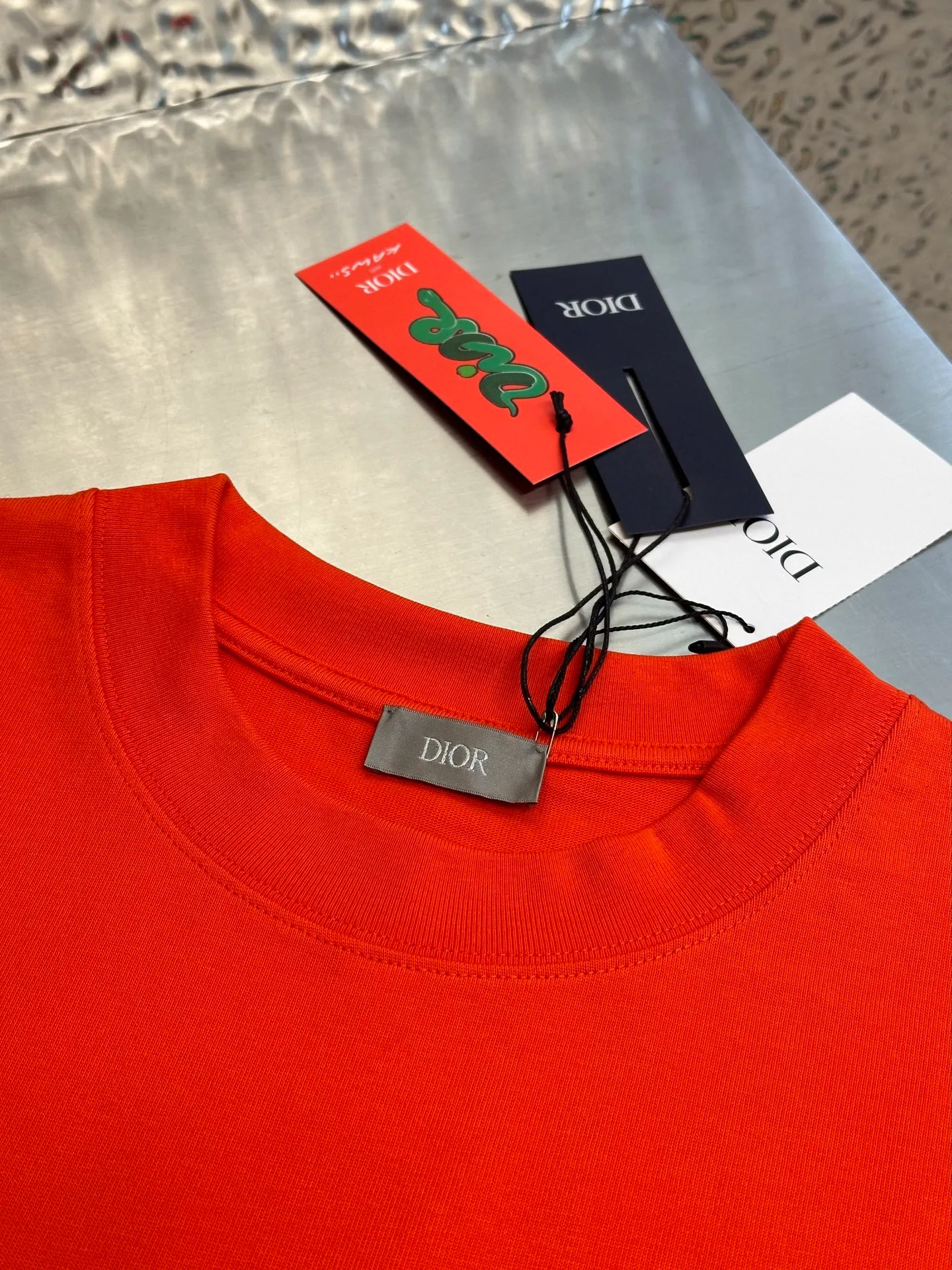 🅿️330 Dior Year of the Snake co-branded bloom-dyed short-sleeves are made of 21s double yarn cotton plain weave. Weighing 320g, it is equipped with 21 pairs of fine cotton yarns and 1*1 horizontal machine woven threads. The front and rear hems are printed with digital direct-injection printing, with large-size patterns throughout.  The front panel is embroidered with a Tajima embroidery machine imported from Japan. The number of embroidery stitches reaches 130,000. The thread color is matched with satin patch to increase stiffness to avoid shifting during the embroidery process. The three-layer embroidery method of short-needle tatami is matched with the new Year of Snake co-branded hangtag size: xs s m l
