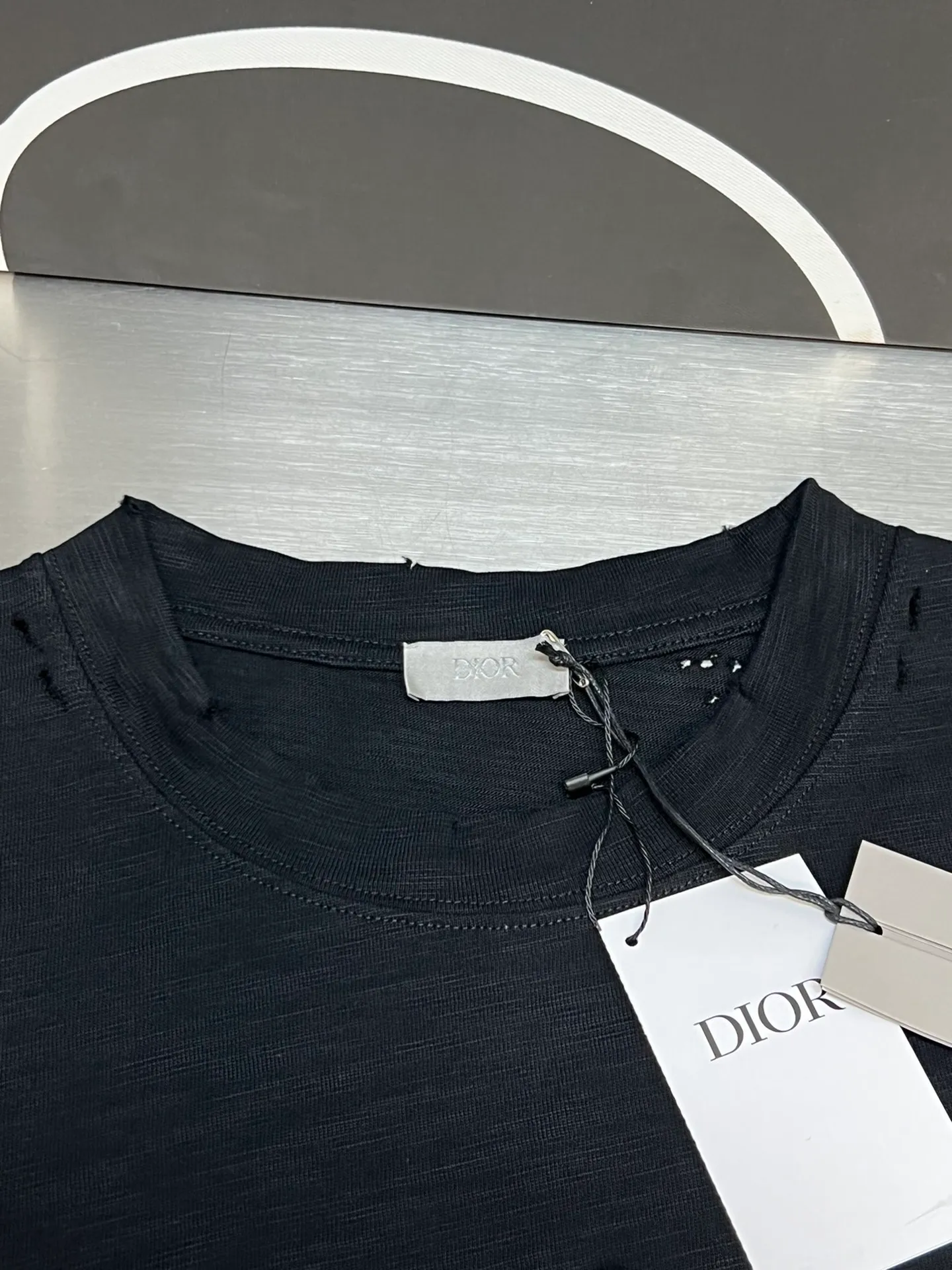 🅿️330 Dior ripped letter print short sleeves The fabric is made of 10s pure cotton slub plain fabric with a weight of 310g. This fabric is used as the collar, and the round collar is manually positioned on a flat machine. The front and back panels are printed with hand-made platen silk screen glue, and the film is engraved with laser dots to create a hollowed-out effect of missing letters. The clothes are designed with bifurcated sides, and the hems of the front and rear panels are cut with a special machine to pick the legs. There are lines on the surface to create a hollow effect. The entire garment is manually positioned and cut with holes, and the garment is fermented and washed to create a nostalgic effect. size：xs s m l