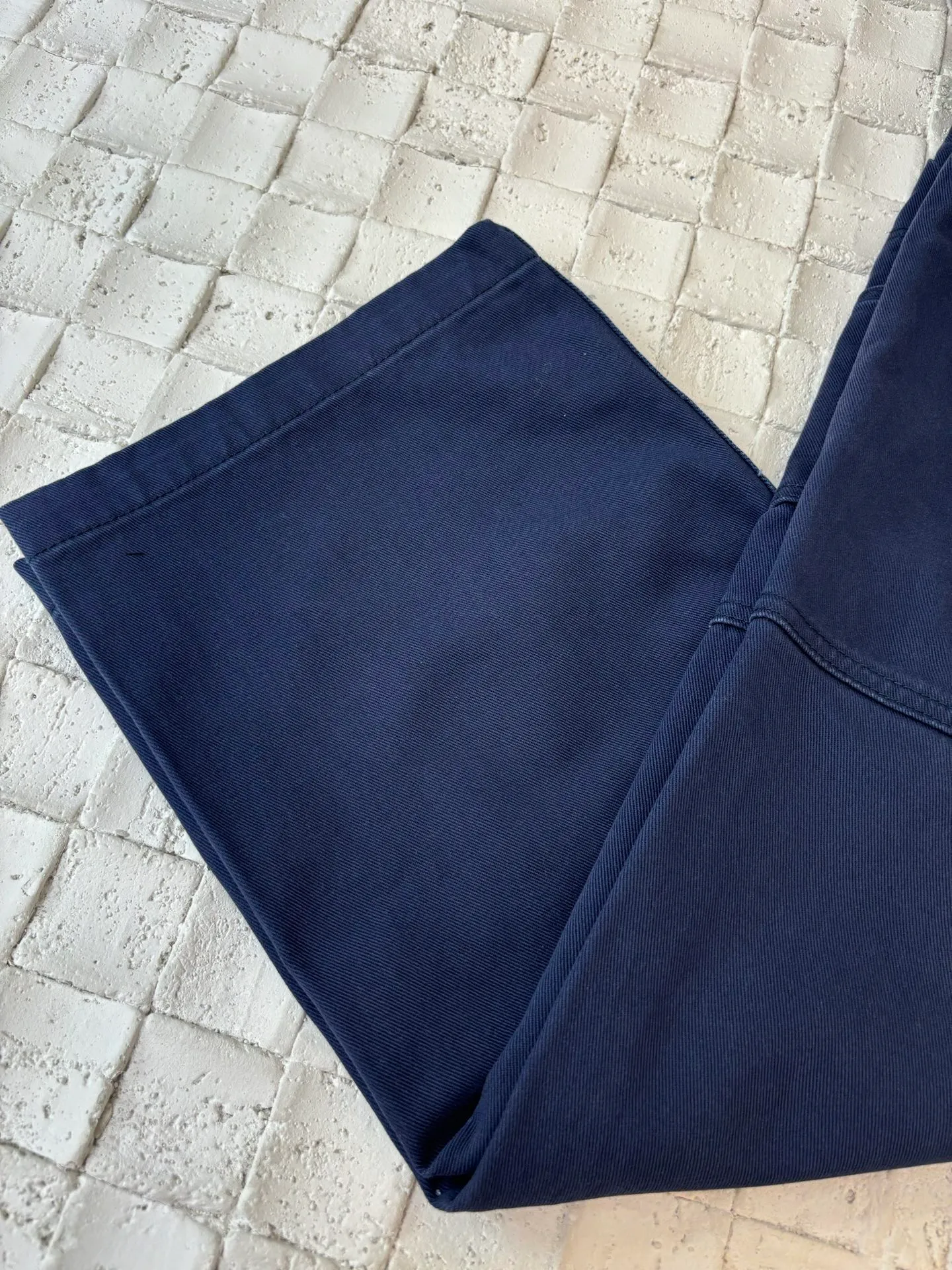 🅿️550 Dio*/Dior 25Fw new workwear blue logging French work pants. Customized twill denim (fixed dyed blue-purple) twill weaving structure. The yarn is customized using long-staple cotton + trace elastic fiber (≤3%) blend. Through the ring spinning + siro spinning composite process, the yarn has high strength and delicate surface. Pre-dyed yarn, cotton yarn is first dip-dyed with indigo 6 times (3-4 times for ordinary jeans) to ensure that the core layer is dyed through. The post-finishing uses nano-scale fixatives to give the blue a deep-sea gradient effect.   The front panel is three-dimensionally spliced, and the five-piece structure of traditional overalls is disassembled into nine asymmetrical pieces. The ergonomic curves are determined through 3D laser scanning. Double-needle differential feeding is used at the seam bone (spacing 2.5mm) to ensure no cracking during stretching.    The back leather is made of calfskin from HAAS leather factory, which is vegetable tanned and hand-rubbed to give it a matte lizard texture. Environmentally friendly dyeing uses water-based dyes, and the edge of the leather label is processed with burnt edge sealing to prevent burrs.    Size: 48/50/52