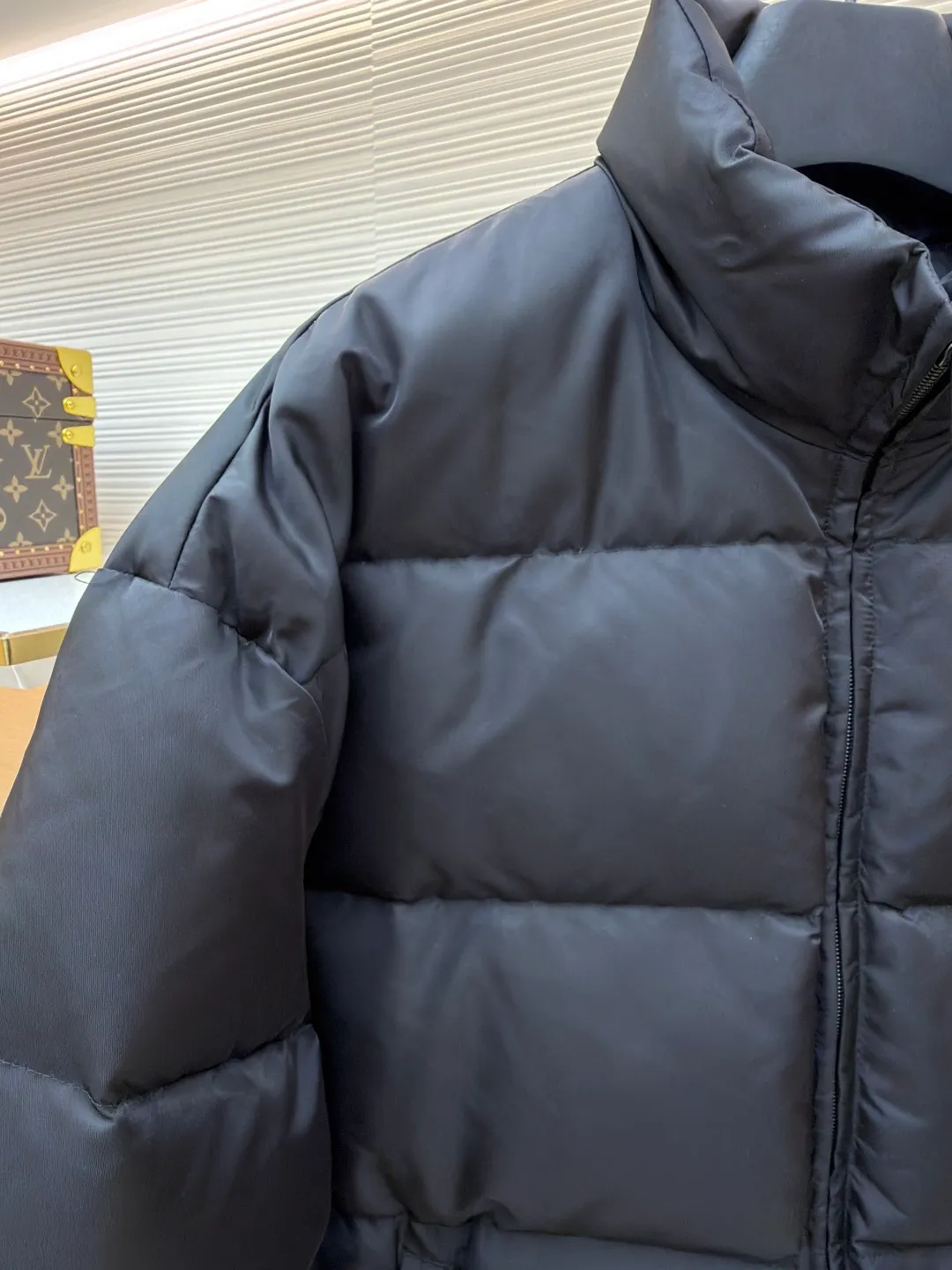 Prada nylon triangle down jacket ●Original version: Purchased and developed by 13557 ●Item number: 1681282-C95 ●Fabric: white duck down fabric ●Technology: mechanical down filling ●Color: black ●Version: fitted version ●Weight: about 1025 grams ●Size: S-M-L-XL ●Description: Made of high-count and high-density nylon woven fabric, it is a lightweight, strong and fine-textured advanced fabric. Its physical complexity lies in the fact that while achieving extreme lightweight, it provides excellent tear resistance and abrasion resistance through a dense fabric structure, solving the industry problem of light weight and durability that are often contradictory. Waterproof coating: This is not a simple film, but a microscopic functional polymer layer coated on the surface of the fabric after it is woven. Its complexity is reflected in its chemical properties: it can effectively reduce the surface tension of the fabric, making it impossible for water droplets to penetrate its fiber gaps, thereby forming a lotus leaf effect and achieving efficient waterproofing. At the same time, this coating usually has a certain degree of breathability, allowing moisture emitted by the body to escape and maintaining a comfortable internal microclimate. This is a precise balancing technology. The laser-burned triangle mark on the chest is the pinnacle of the complexity of the entire garment's craftsmanship. Laser burning is a non-contact precision processing technology. Using a laser beam of specific wavelength and energy, the fibers on the surface of the fabric are vaporized according to a preset digital path. The laser can accurately "carve" every detail of the logo without damaging the underlying fabric structure, with clear and sharp edges and a unique, slightly burning matte texture. This is completely different from traditional embroidery or offset printing. It is integrated with the fabric itself and cannot be peeled off. It also requires extremely high stability in process control - if the energy is slightly weaker, the pattern will be unclear, and if the energy is slightly stronger, it may penetrate the fabric. The core is filled with 90% pure white duck down. "90% pure white duck down" is an indicator that has been strictly sorted. The thermal insulation principle of down is that its three-dimensional velvet can hold a large amount of still air and form an efficient thermal insulation layer. To sum up, every part of this down jacket goes beyond basic functions and embodies full-link innovation and quality control from raw material selection, textile engineering, chemical processing to digital finishing. The overall wiring is straight and delicate, the fabric is comfortable and soft, and the color is consistent without color difference. It can be matched with the same style to create a fashionable look and control various occasions. Customized accessories, complete with three standards, same style for men and women!