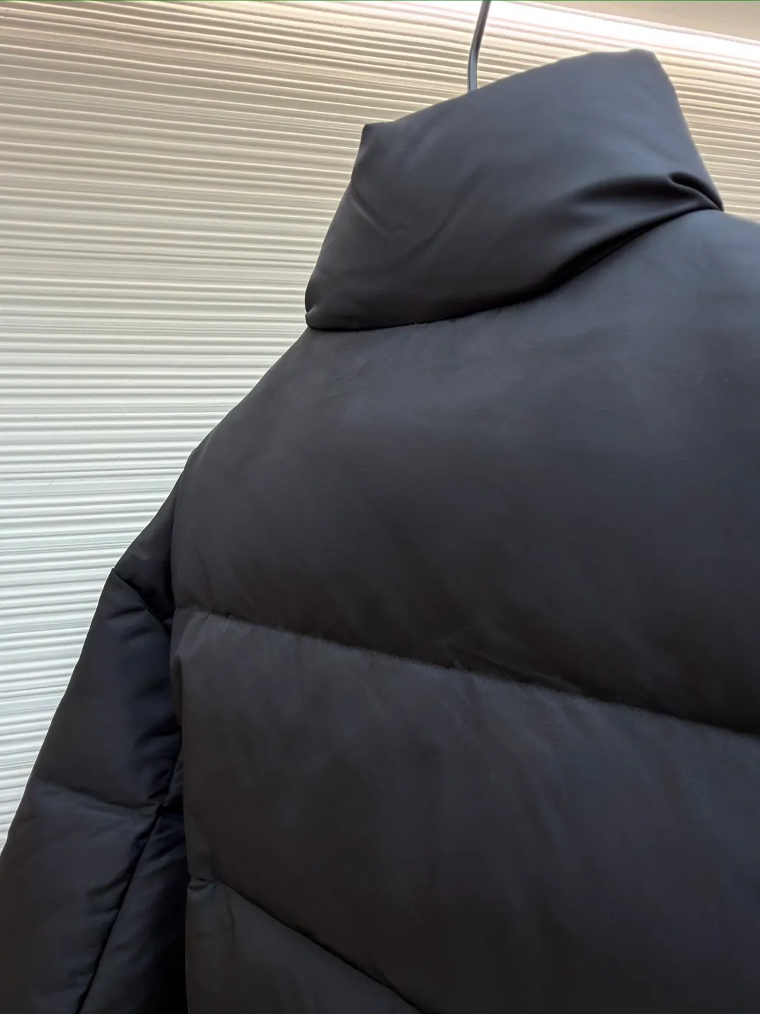Prada nylon triangle down jacket ●Original version: Purchased and developed by 13557 ●Item number: 1681282-C95 ●Fabric: white duck down fabric ●Technology: mechanical down filling ●Color: black ●Version: fitted version ●Weight: about 1025 grams ●Size: S-M-L-XL ●Description: Made of high-count and high-density nylon woven fabric, it is a lightweight, strong and fine-textured advanced fabric. Its physical complexity lies in the fact that while achieving extreme lightweight, it provides excellent tear resistance and abrasion resistance through a dense fabric structure, solving the industry problem of light weight and durability that are often contradictory. Waterproof coating: This is not a simple film, but a microscopic functional polymer layer coated on the surface of the fabric after it is woven. Its complexity is reflected in its chemical properties: it can effectively reduce the surface tension of the fabric, making it impossible for water droplets to penetrate its fiber gaps, thereby forming a lotus leaf effect and achieving efficient waterproofing. At the same time, this coating usually has a certain degree of breathability, allowing moisture emitted by the body to escape and maintaining a comfortable internal microclimate. This is a precise balancing technology. The laser-burned triangle mark on the chest is the pinnacle of the complexity of the entire garment's craftsmanship. Laser burning is a non-contact precision processing technology. Using a laser beam of specific wavelength and energy, the fibers on the surface of the fabric are vaporized according to a preset digital path. The laser can accurately "carve" every detail of the logo without damaging the underlying fabric structure, with clear and sharp edges and a unique, slightly burning matte texture. This is completely different from traditional embroidery or offset printing. It is integrated with the fabric itself and cannot be peeled off. It also requires extremely high stability in process control - if the energy is slightly weaker, the pattern will be unclear, and if the energy is slightly stronger, it may penetrate the fabric. The core is filled with 90% pure white duck down. "90% pure white duck down" is an indicator that has been strictly sorted. The thermal insulation principle of down is that its three-dimensional velvet can hold a large amount of still air and form an efficient thermal insulation layer. To sum up, every part of this down jacket goes beyond basic functions and embodies full-link innovation and quality control from raw material selection, textile engineering, chemical processing to digital finishing. The overall wiring is straight and delicate, the fabric is comfortable and soft, and the color is consistent without color difference. It can be matched with the same style to create a fashionable look and control various occasions. Customized accessories, complete with three standards, same style for men and women!