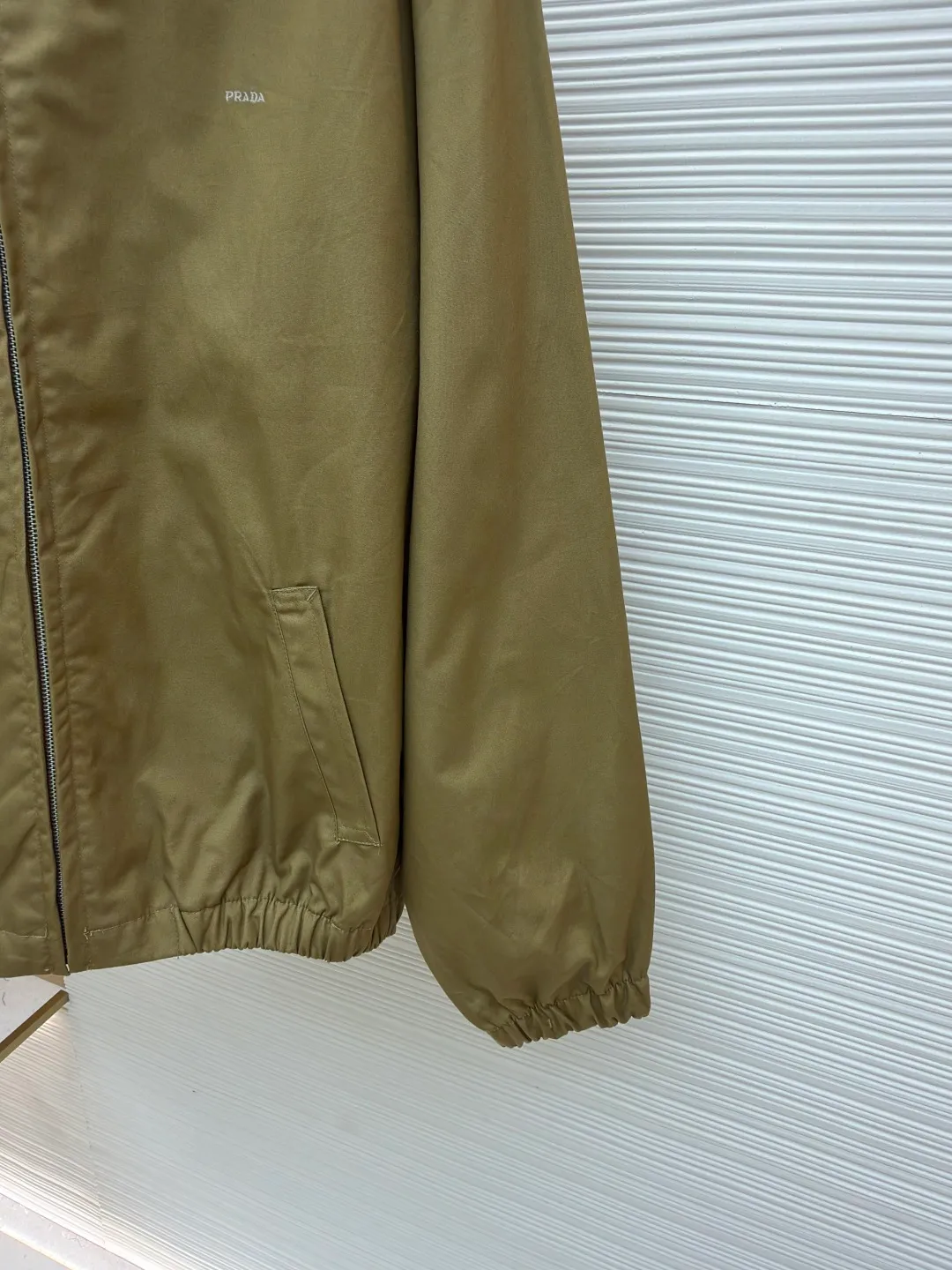 PRADA Embroidered Logo Zipper Executive Jacket ●Original version: Purchased and developed for 19300 ●Item number: 1680845-B60 ●Material: Xinjiang lamb cotton fabric ●Technology: embroidery production ●Version: fitted version ●Weight: about 740 grams ●Size: 46-48-50-52 ●Description: 32-count cotton yarn is dyed and woven. This cotton material is made of Xinjiang small white cotton, which is dyed 1:1 after the original custom weaving. The same fabric is matched with the same material and is custom-woven and dyed. The fabric took two months to make. The chest embroidery is made using an imported embroidery machine. The effect presents a three-dimensional visual sense, and each letter line is clear. The inner lining is decorated with hyacinths, dates are punched, the bags are opened, etc... The workmanship of the entire garment is close to 30%. The zipper is electroplated in bright white No. 5, with the brand's logo laser-engraved on the surface, and the buttons are made of natural resin. This cotton style features a relaxed style with a soft, lightweight silhouette. The overall wiring is straight and delicate, the fabric is comfortable and soft, and the color is consistent without color difference. It can be matched with the same style to create a fashionable look and control various occasions. Customized accessories, complete with three standards, same style for men and women!