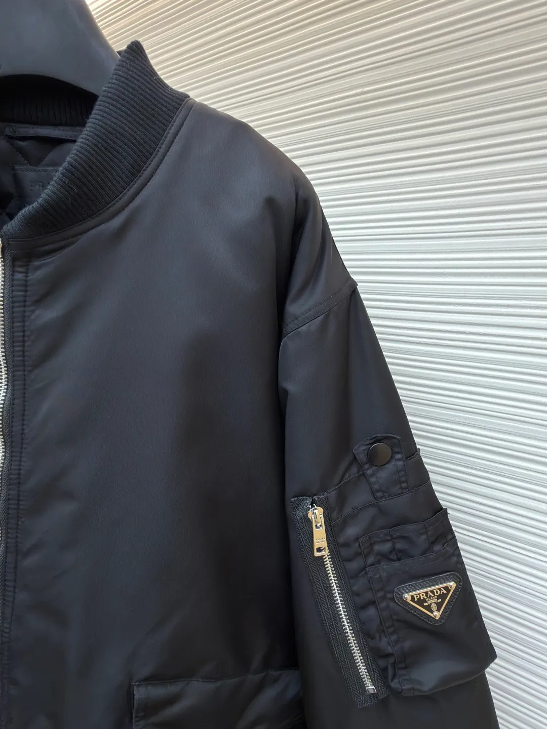 Prada sleeve bomber bomber jacket cotton ●Original version: Purchased and developed at 18475 ●Item number: 1682145-C45 ●Fabric: Regenerated nylon fabric ●Technology: Positioning cutting machine production ●Color: black ●Version: fitted version ●Weight: about 1115 grams ●Size: S-M-L-XL ●Description: The fabric is made of customized regenerated nylon. The main features of this nylon fabric are environmental protection, circular economy, performance and texture, wear resistance The look and feel remains premium. The filling is made of high-quality pearl cotton. This cotton is not a traditional wadding, but a hollow three-dimensional crimped fiber formed through a special process. Diamond-shaped mesh stitching inside and outside prevents the down from shifting and accumulating during use, ensuring even distribution of thermal insulation properties. Customized hardware accessories include triangle labels, engraved zippers, and buttons. The overall wiring is straight and delicate, the fabric is comfortable and soft, and the color is consistent without color difference. It can be matched with the same style to create a fashionable look and control various occasions. Customized accessories, complete with three standards, same style for men and women!