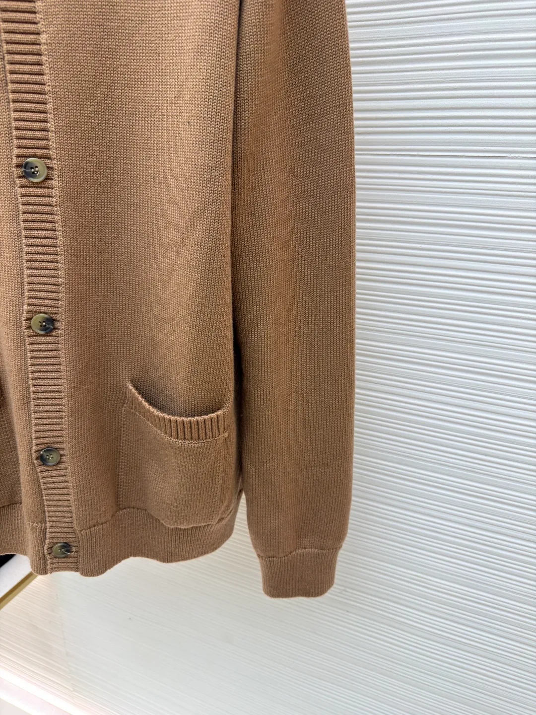Prada round neck single-breasted cashmere cardigan ●Original version: Purchased and developed by 10189 ●Item number: 1681575-A85 ●Fabric: wool blended fabric ●Technology: knitted ●Color: camel ●Version: Fitted version ●Weight: about 830 grams ●Size: S-M-L-XL ●Description: This knitted cardigan is made of high-quality wool blended fabric, with a soft and delicate feel and excellent warmth retention properties. The body features a classic round neck design for a comfortable fit. The front placket is closed with a single-breasted button, making it easy to put on and take off and look neat. There are symmetrical pockets on both sides, which are practical and enhance the overall look. The knitted texture is clear and even, demonstrating exquisite craftsmanship. Ready-made garments undergo strict quality inspection to ensure that each piece meets high standards. Whether worn with a shirt or a T-shirt, this cardigan can show its unique fashion taste and texture. The overall wiring is straight and delicate, the fabric is comfortable and soft, and the color is consistent without color difference. It can be matched with the same style to create a fashionable look and control various occasions. Customized accessories, complete with three standards, same style for men and women!