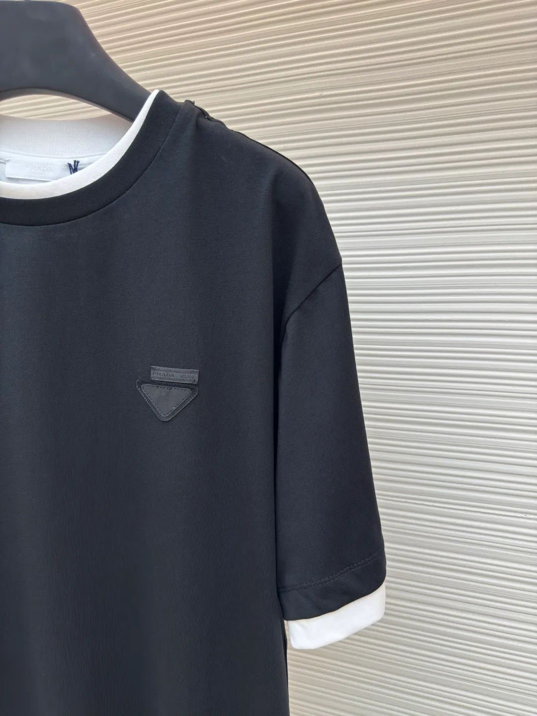 Prada triangular cloth label round neck short sleeves ●Authentic product: Purchased and developed by 4570 ●Item number: 1680228-A10 ●Fabric: Special woven dense cotton fabric ●Technology: Made on positioning cutting machine ●Version: Fitted version ●Weight: about 260 grams ●Size: XS-S-M-L ●Description: Made of 24S special woven compact cotton fabric, 185g; with 40S double yarn thread, 220g. The strength of compact yarn is higher than that of traditional single yarn. The single fibers in compact yarn are closely arranged, which helps to improve the strength of the yarn. The ends of the fibers are all twisted into the yarn, so the yarn is very tight and the yarn has a smooth appearance with less hairiness. Compact spinning yarn has higher strength and less hairiness, making it less prone to fraying. The characteristics of the classic brand's triangular woven label are innovative breakthroughs from three dimensions: material collision, structural craftsmanship and symbolic narrative. The three-dimensional thickness is formed by hot-pressing composite. Because it can be woven with woven yarn raw materials, laser cut and restored, it has different characteristics in terms of temperature resistance. The classic round neck basic version design adopts a double-layer neckline and asymmetrical hem with a fake two-piece structure, and the side seams form a three-dimensional box silhouette. Create a visual dislocation effect through the collision and stacking of color blocks. The triangle logo on the front chest is heat-embossed to create a matte and slightly reflective contrast with the main fabric. The overall wiring is straight and delicate, the fabric is comfortable and soft, and the color is consistent without color difference. It can be matched with the same style to create a fashionable look and control various occasions. Customized accessories, complete with three standards, same style for men and women!